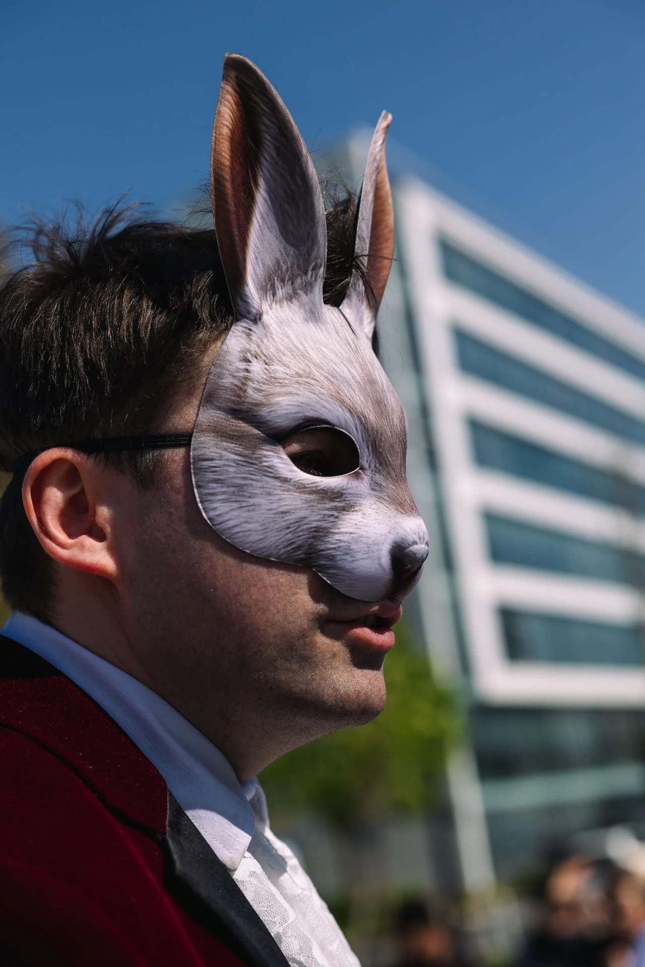 Person portant un masque de style lapin avec des oreilles en pleine ville.