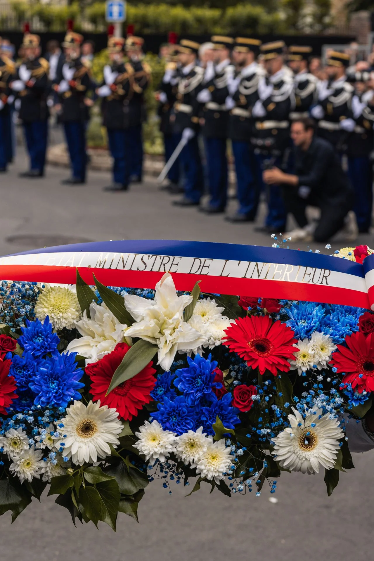 Un bouquet de fleurs tricolores (bleu, blanc, rouge) avec une inscription en français : "MINISTRE DE L'INTERIEUR"