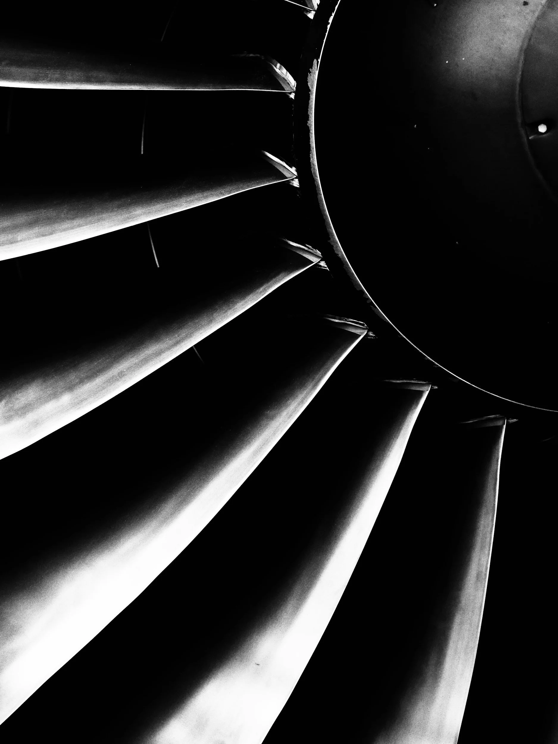 Close-up of a black and white spiral staircase viewed from above.