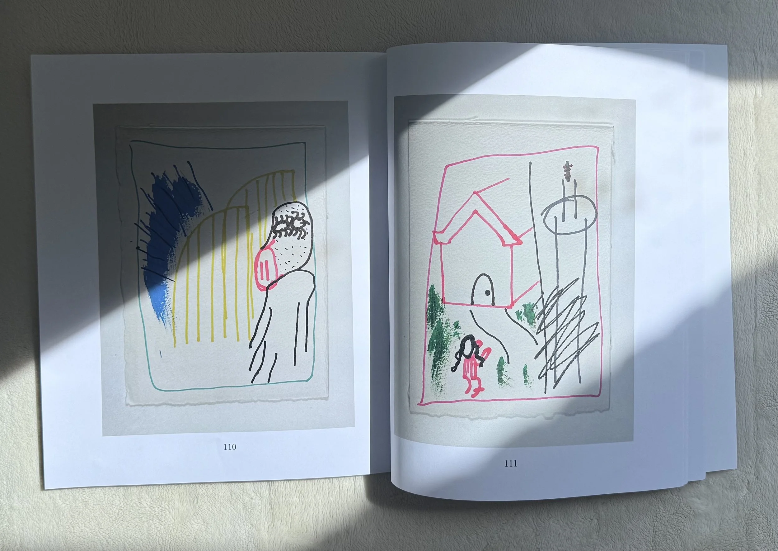 Open sketchbook depicting colorful, abstract, and minimalist line artwork of human figures and geometric shapes, with shadows cast across the pages.