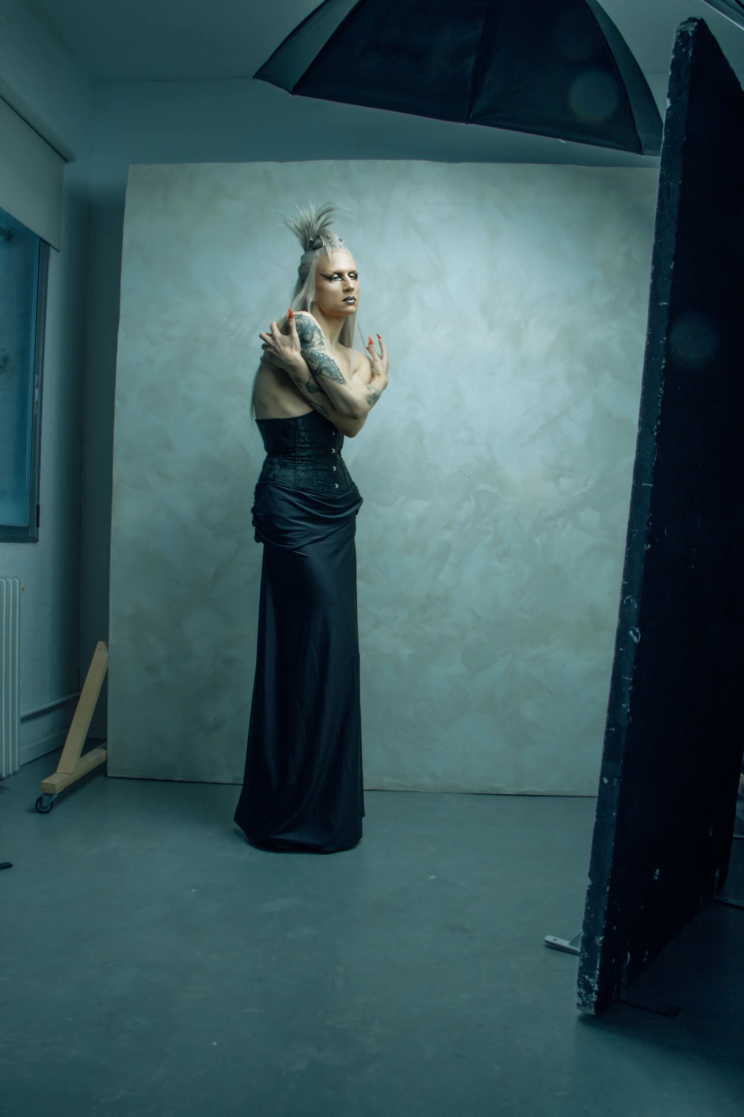 Imagen editorial que revela el proceso creativo al integrar moda, escenografía e iluminación en una propuesta de fuerte personalidad visual.