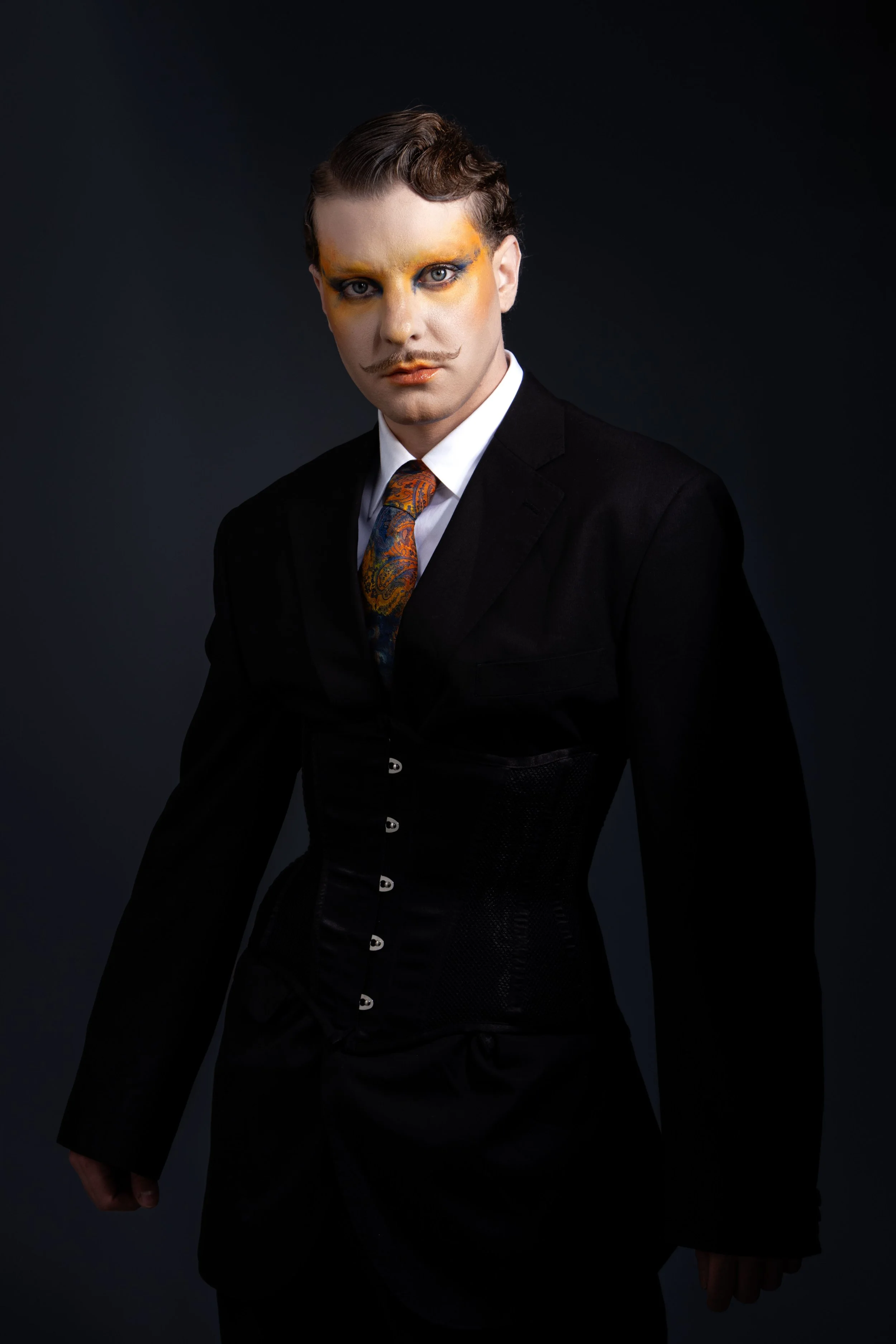 Imagen editorial que combina sastrería, maquillaje artístico y dirección de arte para desarrollar un retrato de marcado carácter escénico.