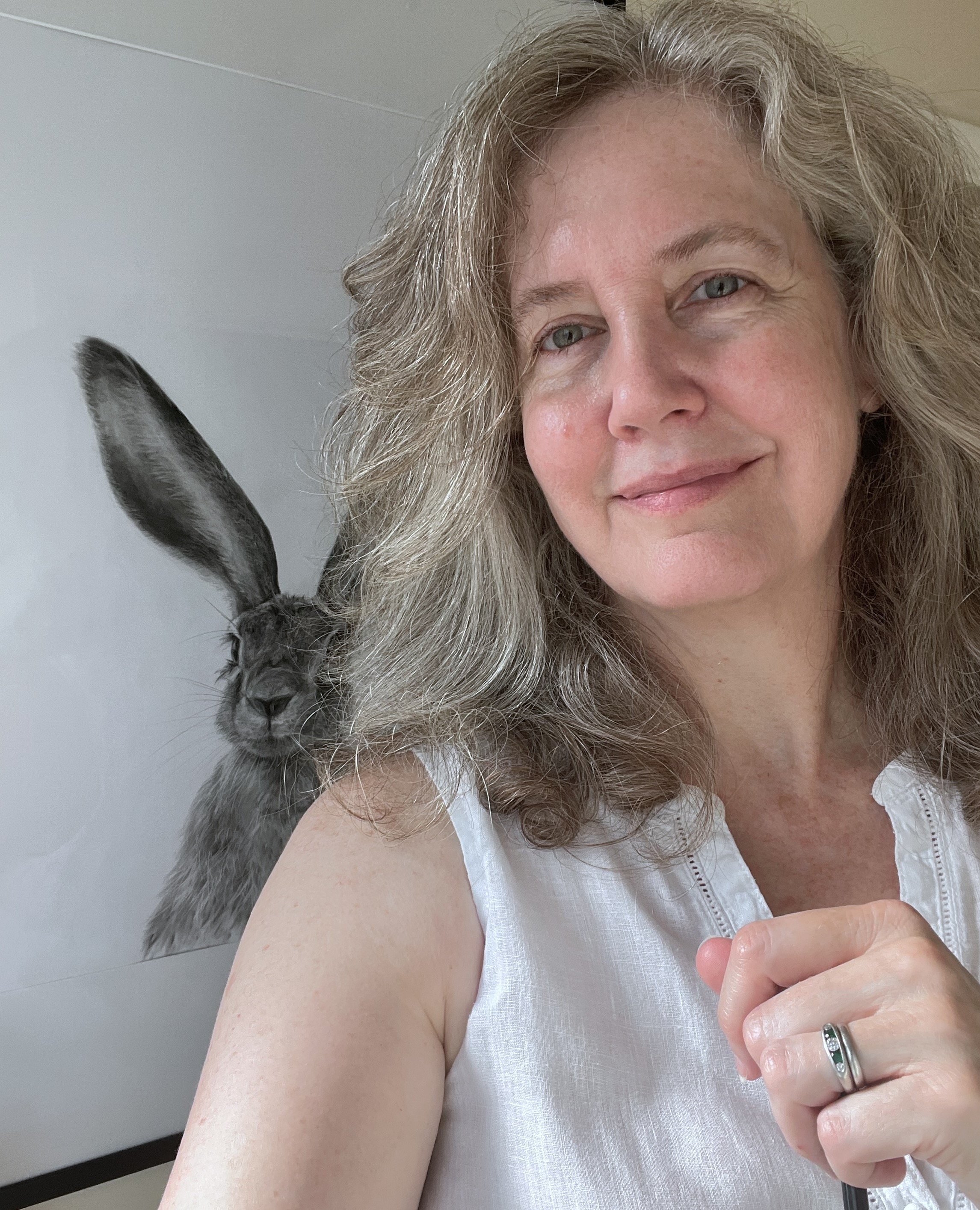 Wildlife artist Fiona Ison beside her charcoal drawing of a hare.