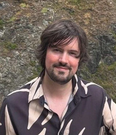 Outdoor portrait of Blaine Shackleton against a natural rocky background.