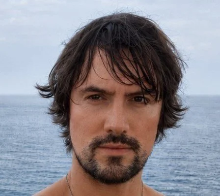 Outdoor portrait of Blaine Shackleton with the sea in the background.