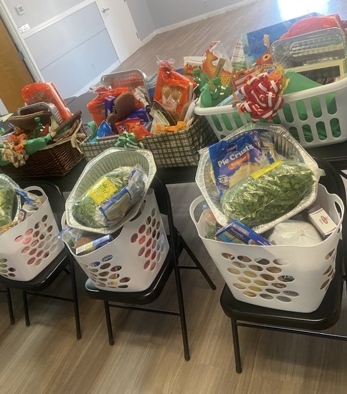 Multiple shopping baskets filled with groceries and food items on chairs.