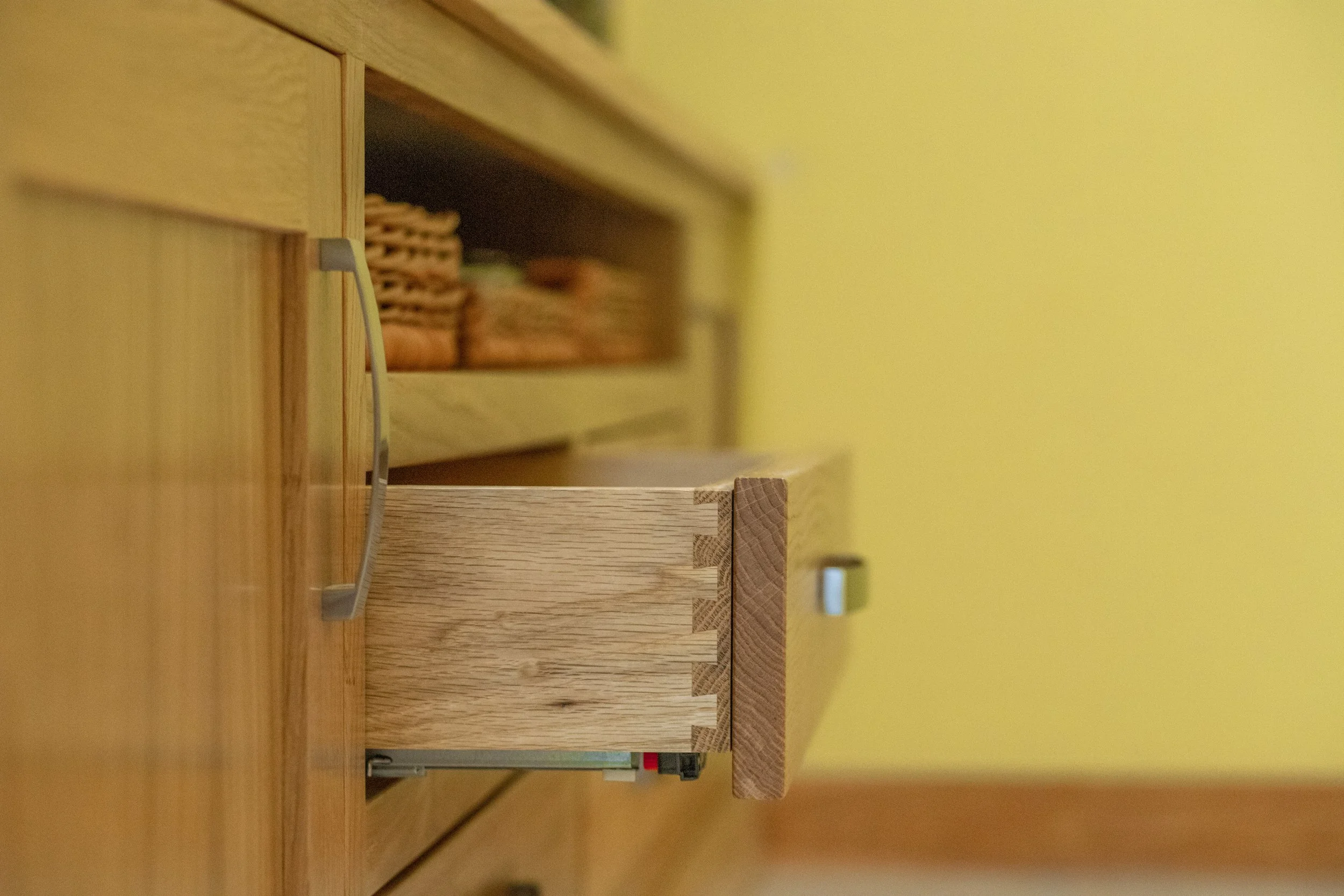 Wooden blocks stacked vertically with a yellow wall in the background.