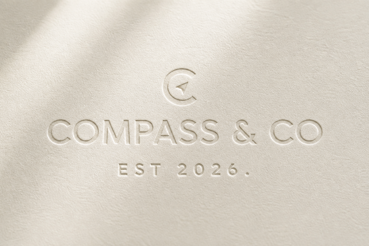 Compass & Co. logo blind-embossed on warm cream paper.