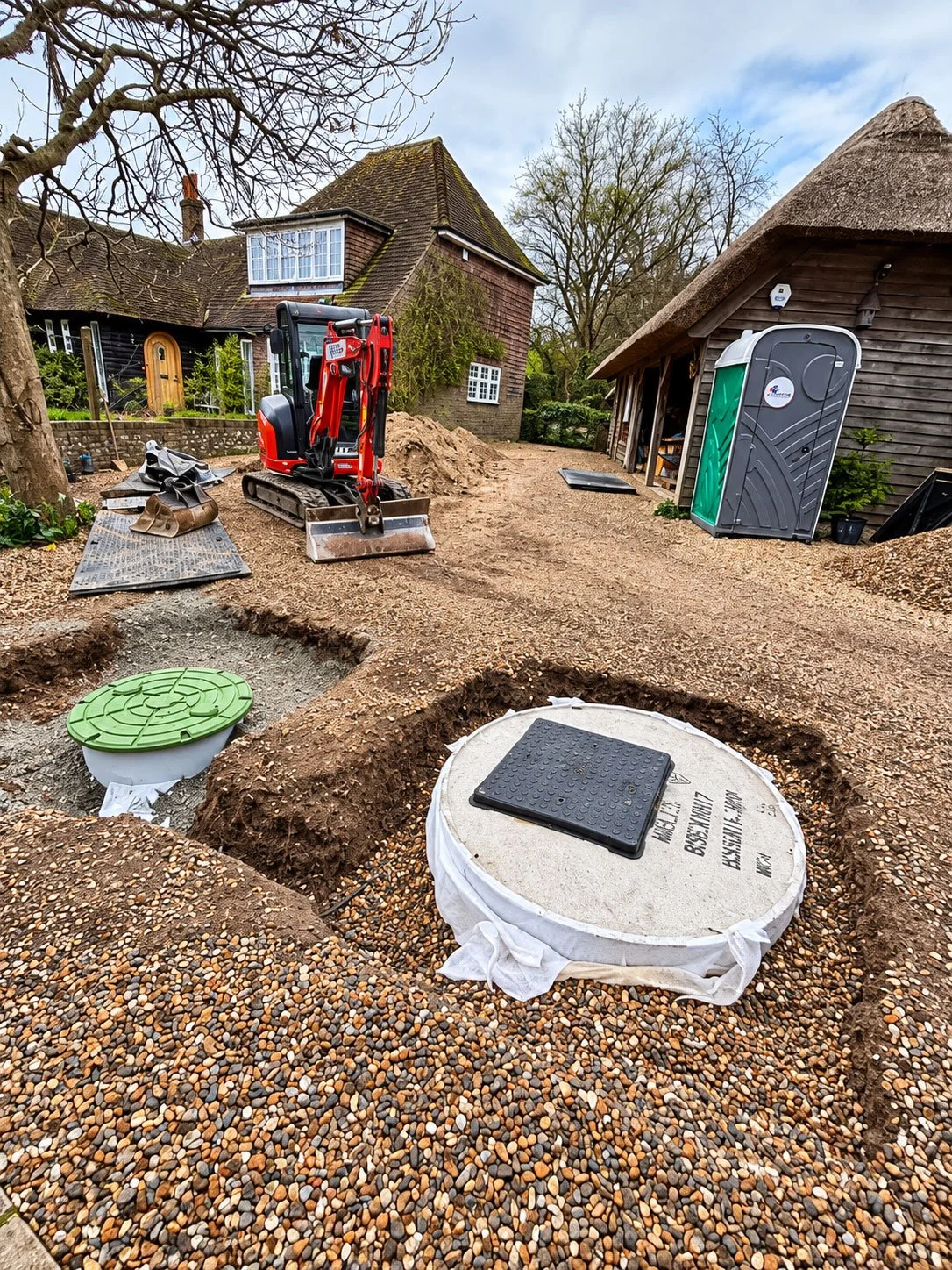 Drainage system replacement in progress beside a rural house.