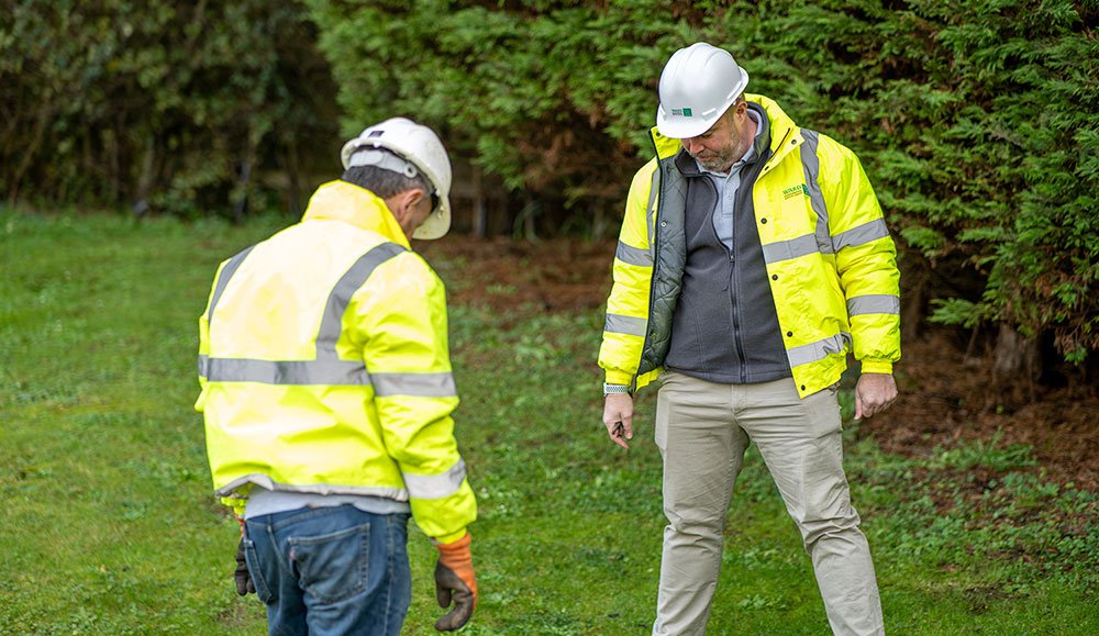 WES staff examining drainage in a garden.