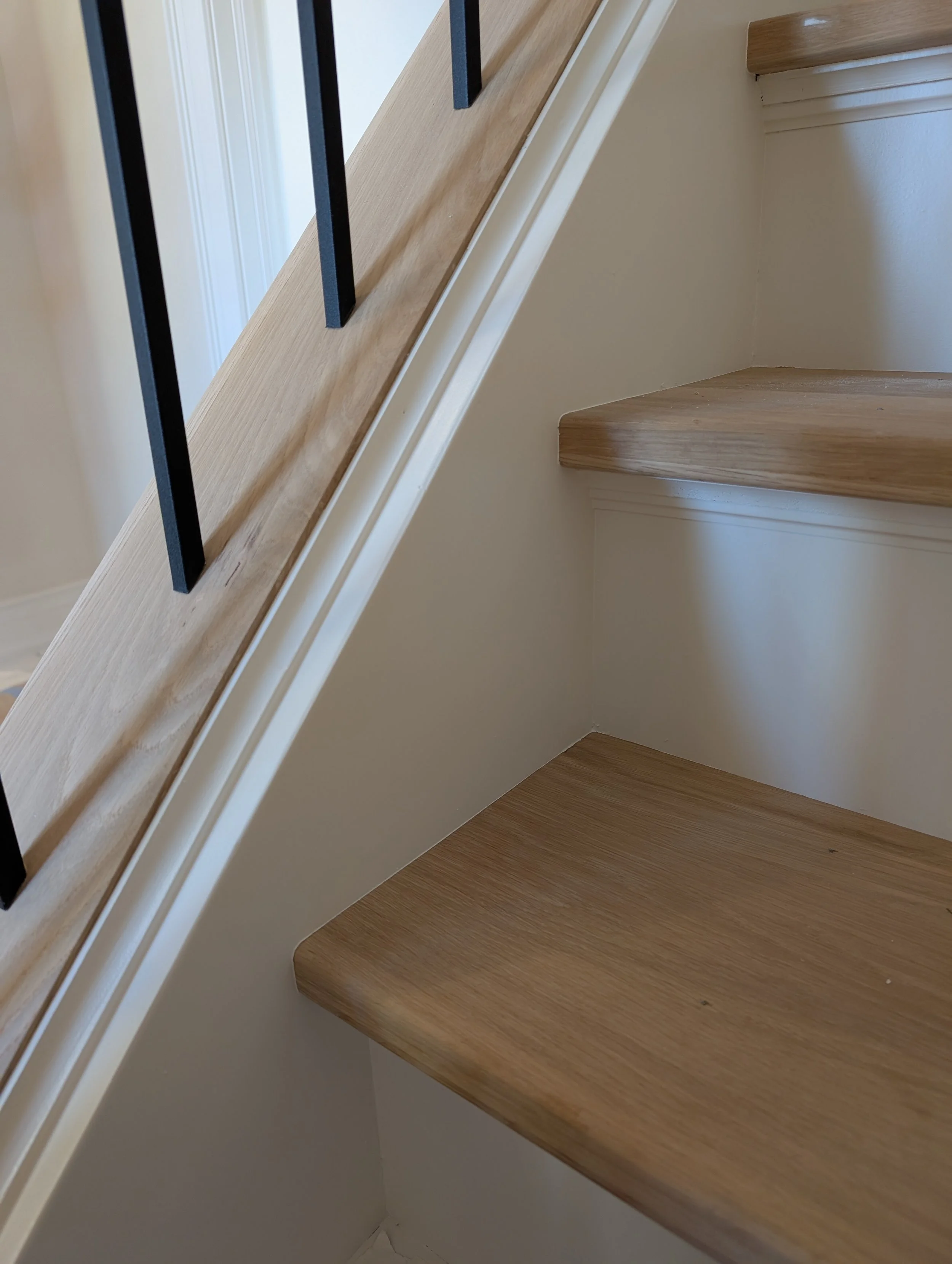 AFTER: same staircase remodeled with white oak treads and railings