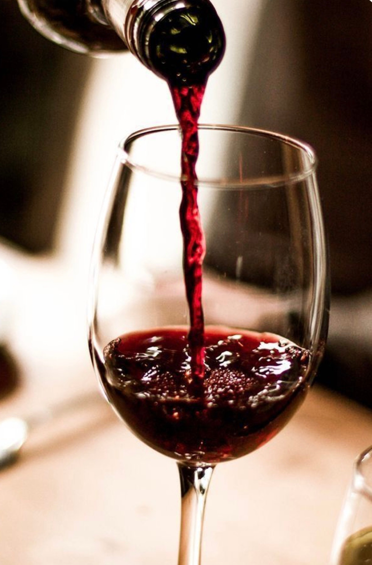 Red wine being poured into a wine glass.