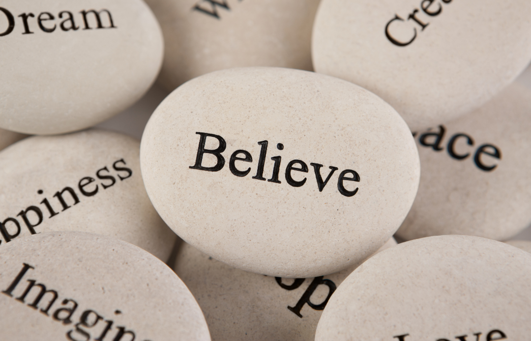 Close-up of white decorative stones with words like "Believe," "Dream," and "Happiness" printed on them.