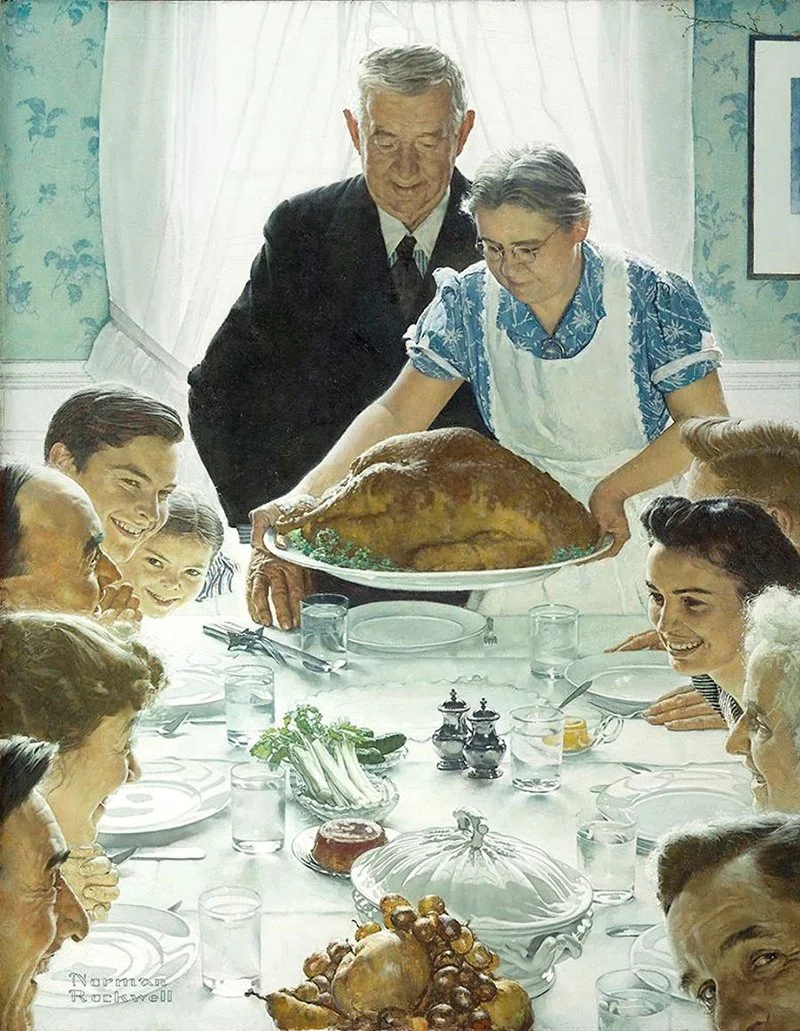A family gathers around a dining table as a couple presents a large roasted turkey for Thanksgiving dinner.