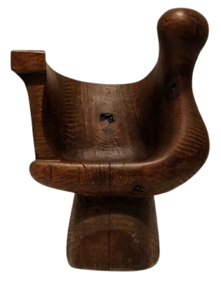 A sculptural wooden chair by JB Blunk, with an organic form carved from natural wood.