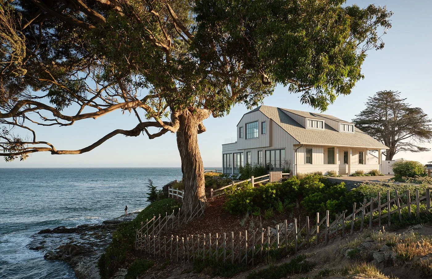 A home overlooking the Pacific Ocean, with expansive glazing and landscaped grounds.