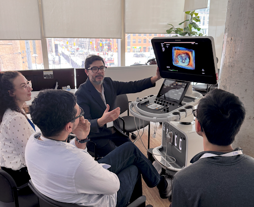 Toronto Interventional Echo Summit (TIES) instructor demonstrating 3D cardiac imaging on an echocardiography system to a small group of participants.