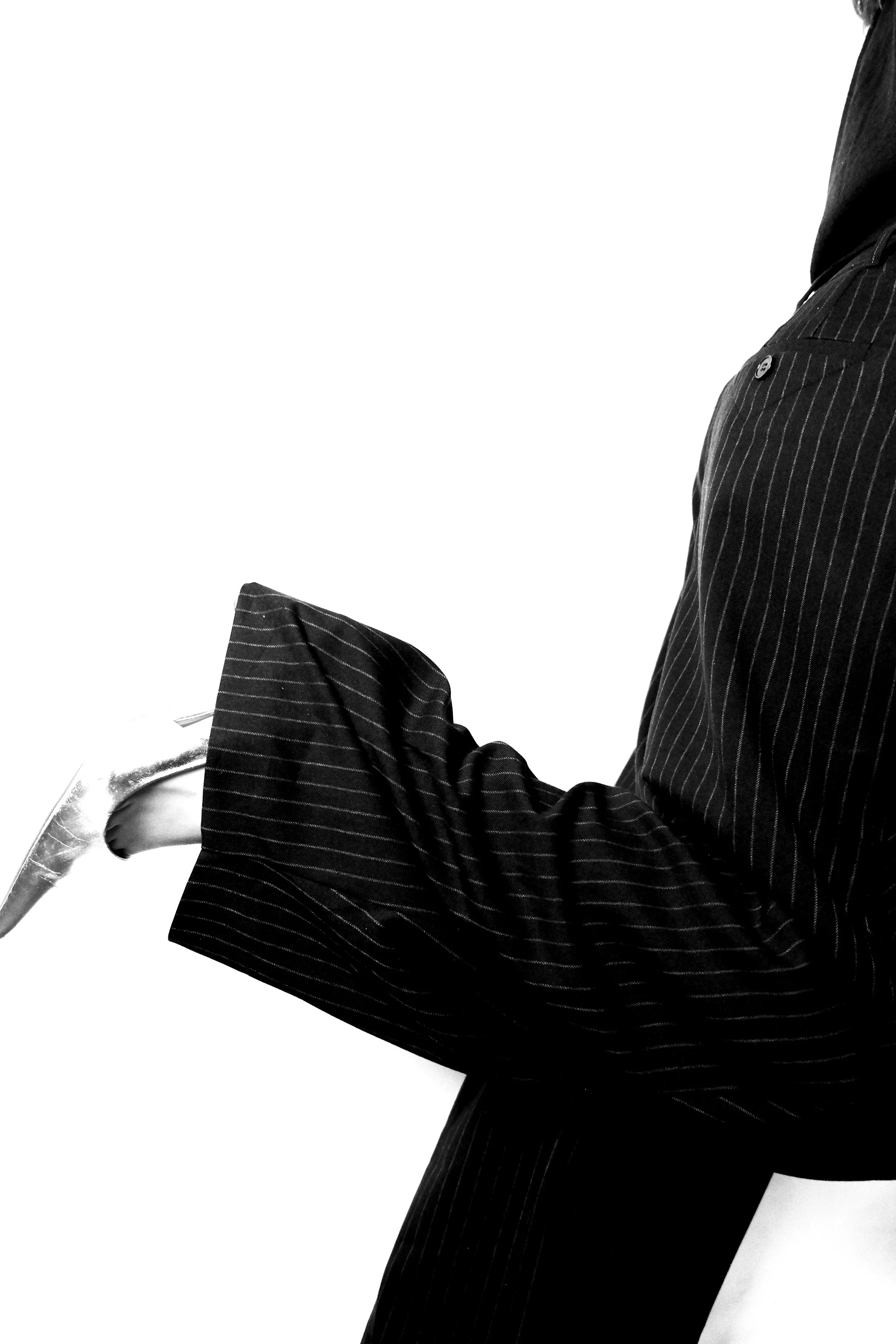Close-up of a person wearing a pinstripe suit and holding a horse halter.