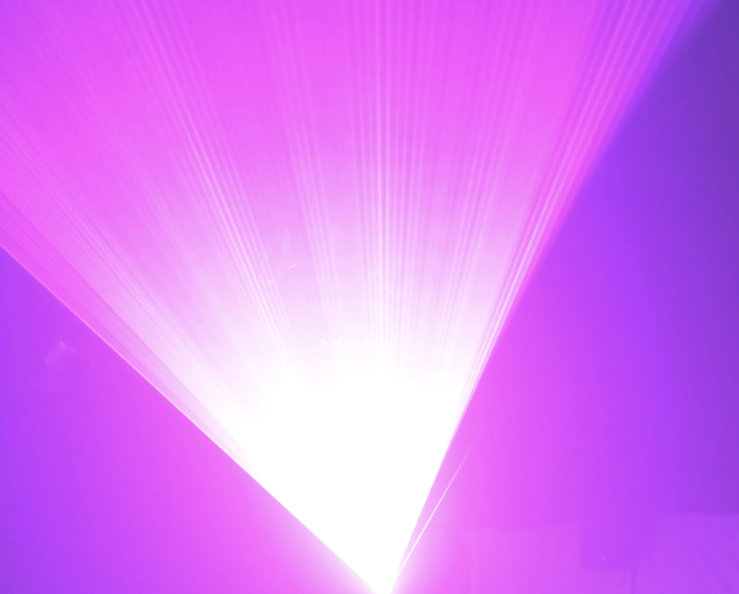 A vibrant pink and purple gradient background with radiating light beams.