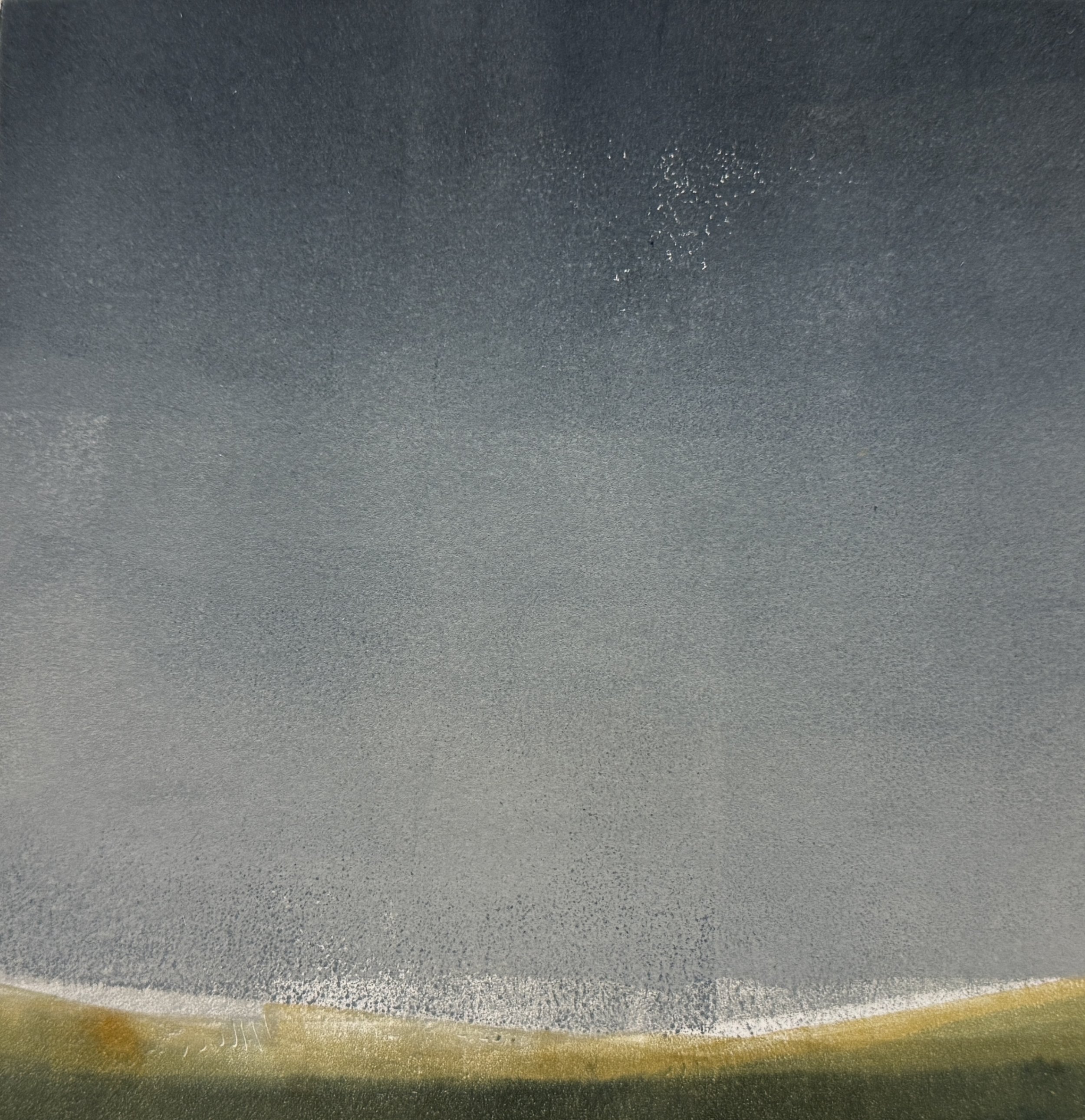 Close-up of a dark gray textured surface with some shiny spots in the center and a yellowish edge at the bottom.