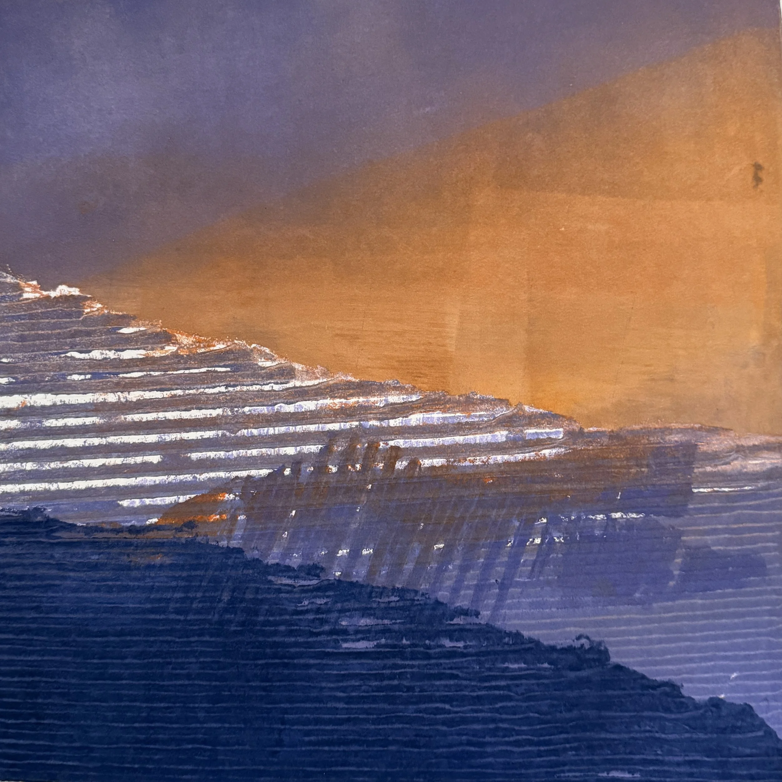 Close-up of a textured metallic surface with a gradient from dark blue to copper and orange hues, featuring horizontal ridges.