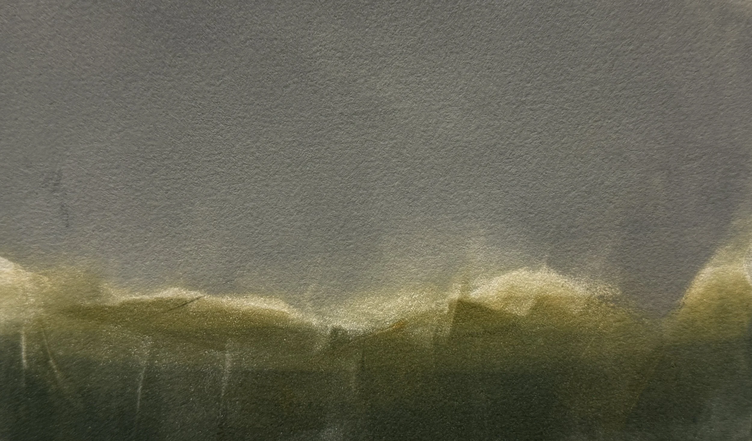 Close-up of a textured gray paper with some yellowish-green edges visible at the bottom