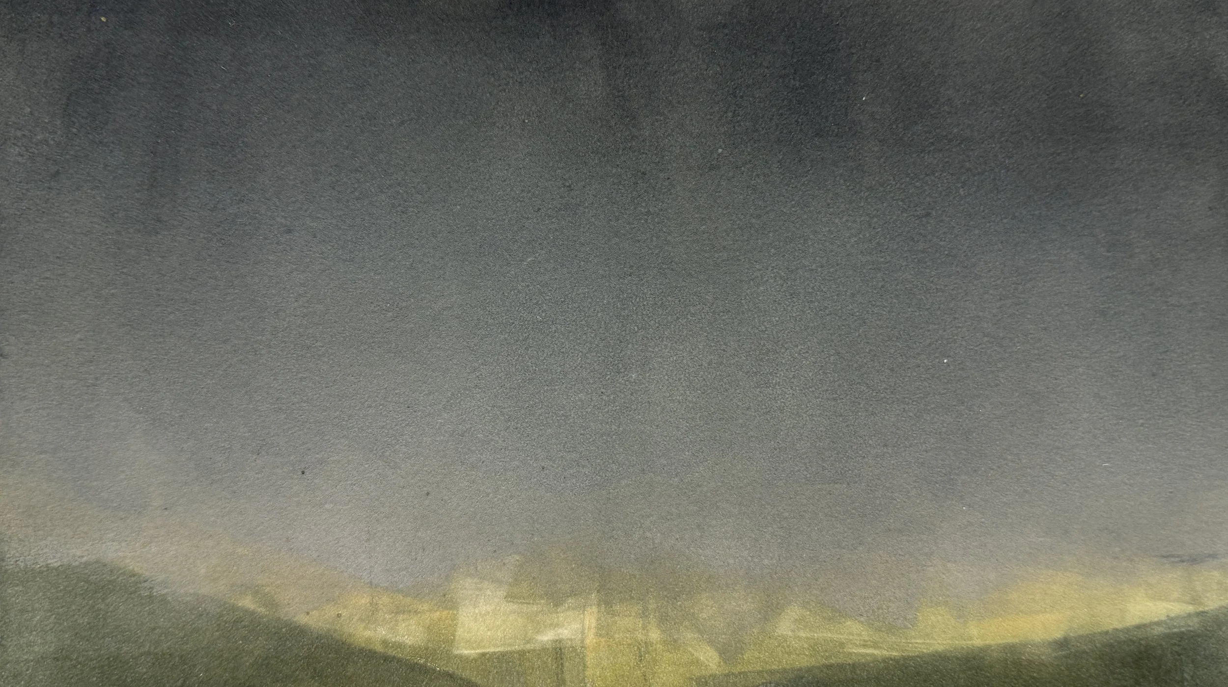 A landscape photograph of a mountain range during sunset with a cloudy sky.