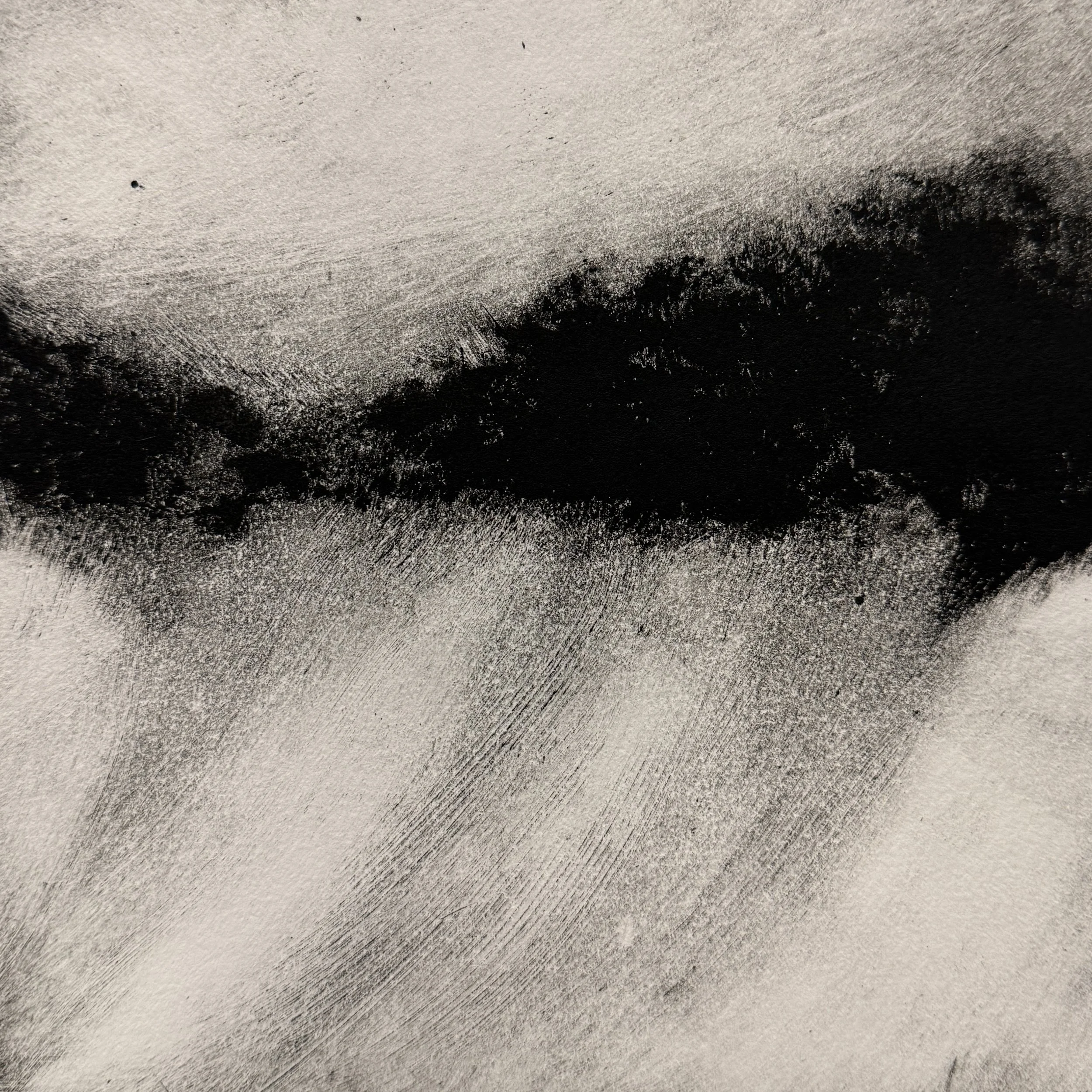A close-up of sandy or dusty surface with darker areas and textured details.