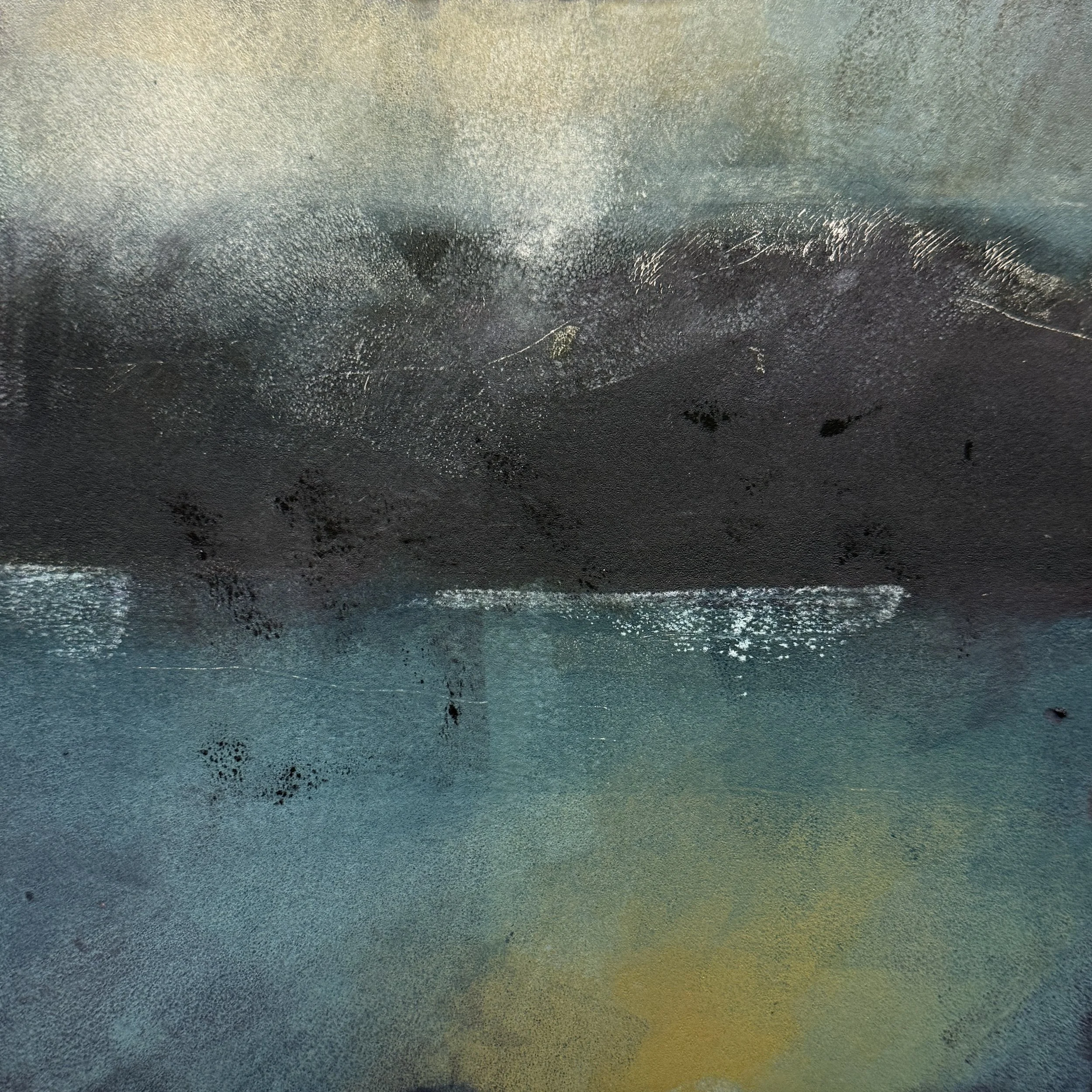 Close-up of a textured, metallic surface with shades of gold, silver, and black.