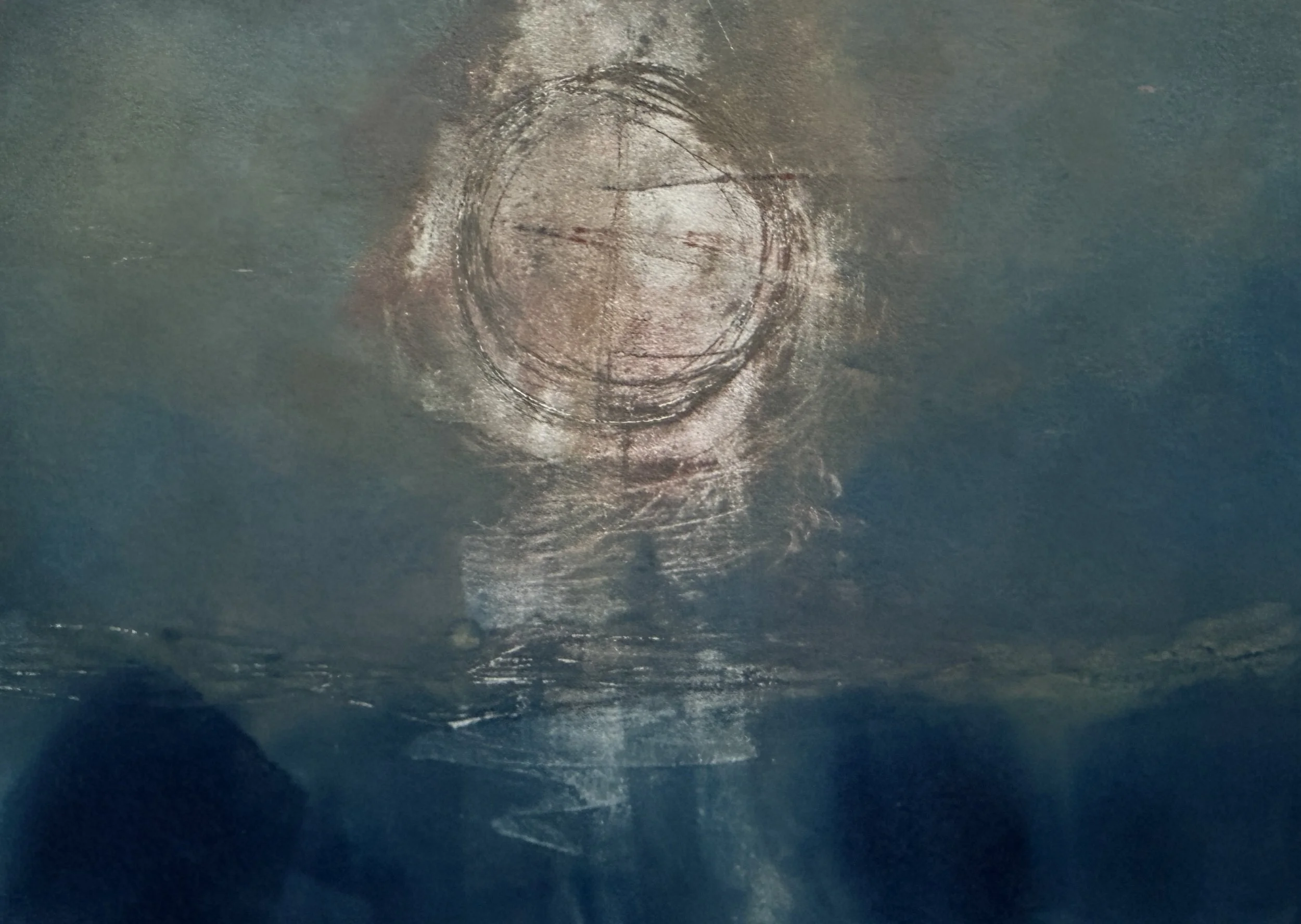 A person swimming underwater with swim fins and goggles, in a large body of water with a sunken boat in the background.
