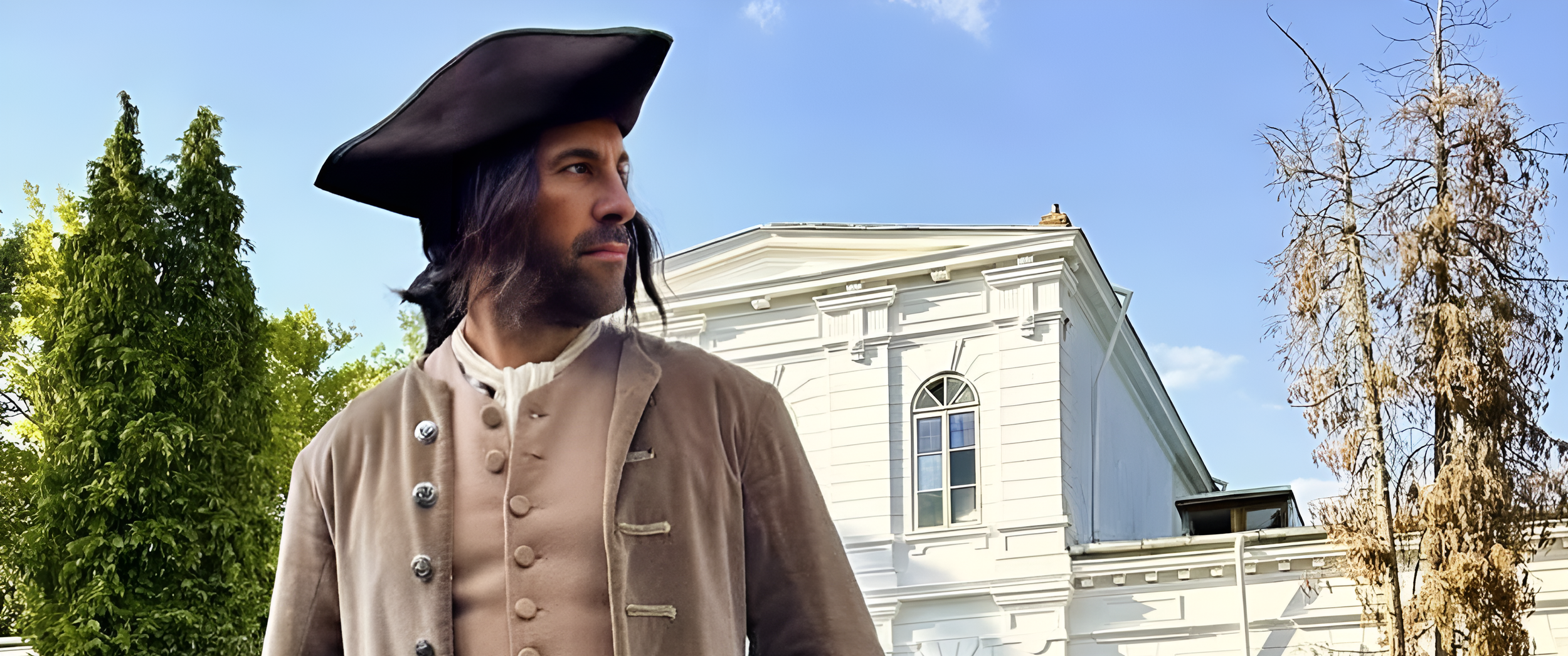 Man dressed as a historical figure in front of a white church or building, with trees and a clear blue sky in the background