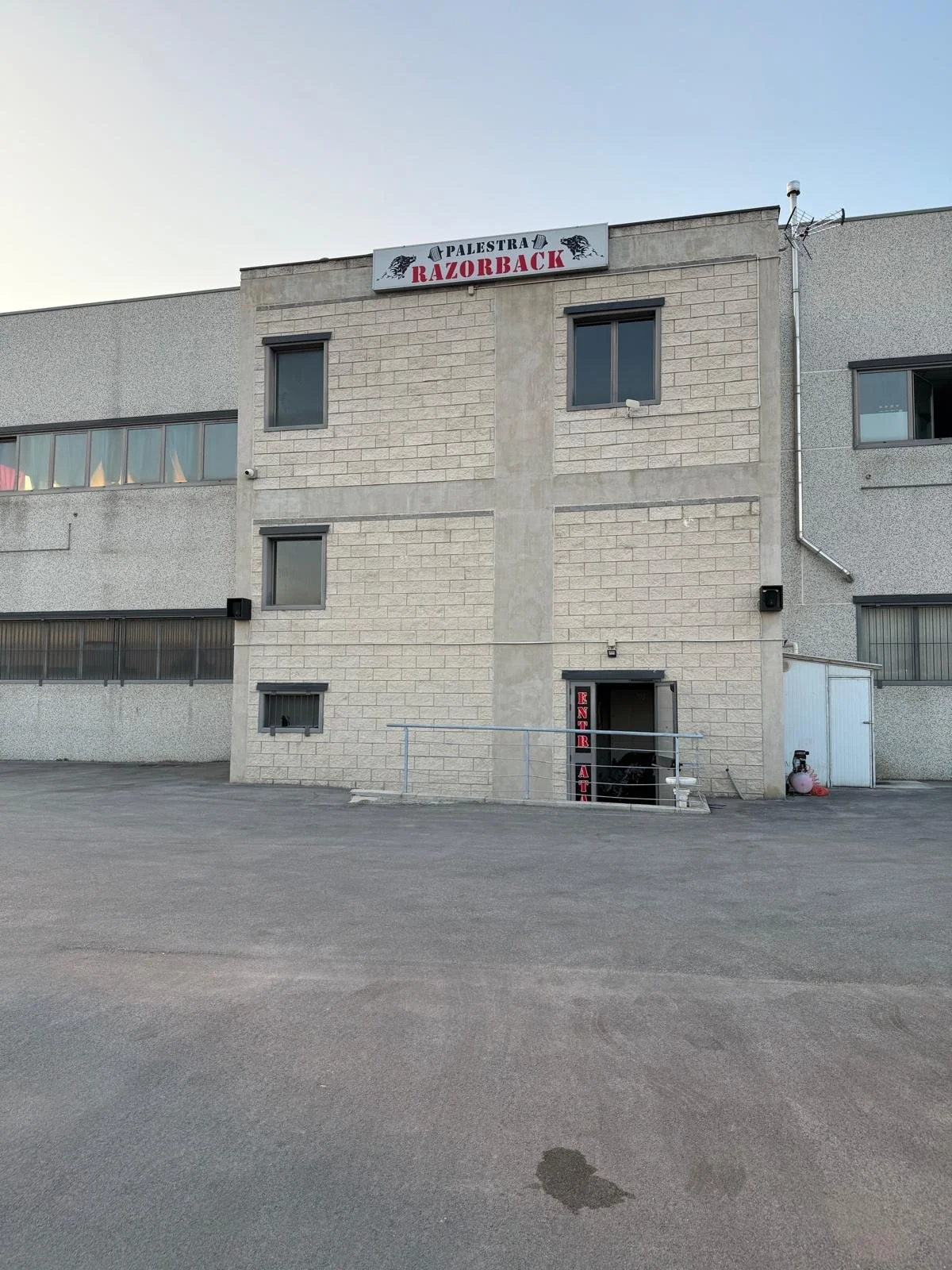 Facciata di un edificio con un cartello che dice 'PALESTRA RAZORBACK' con due leoni stilizzati.