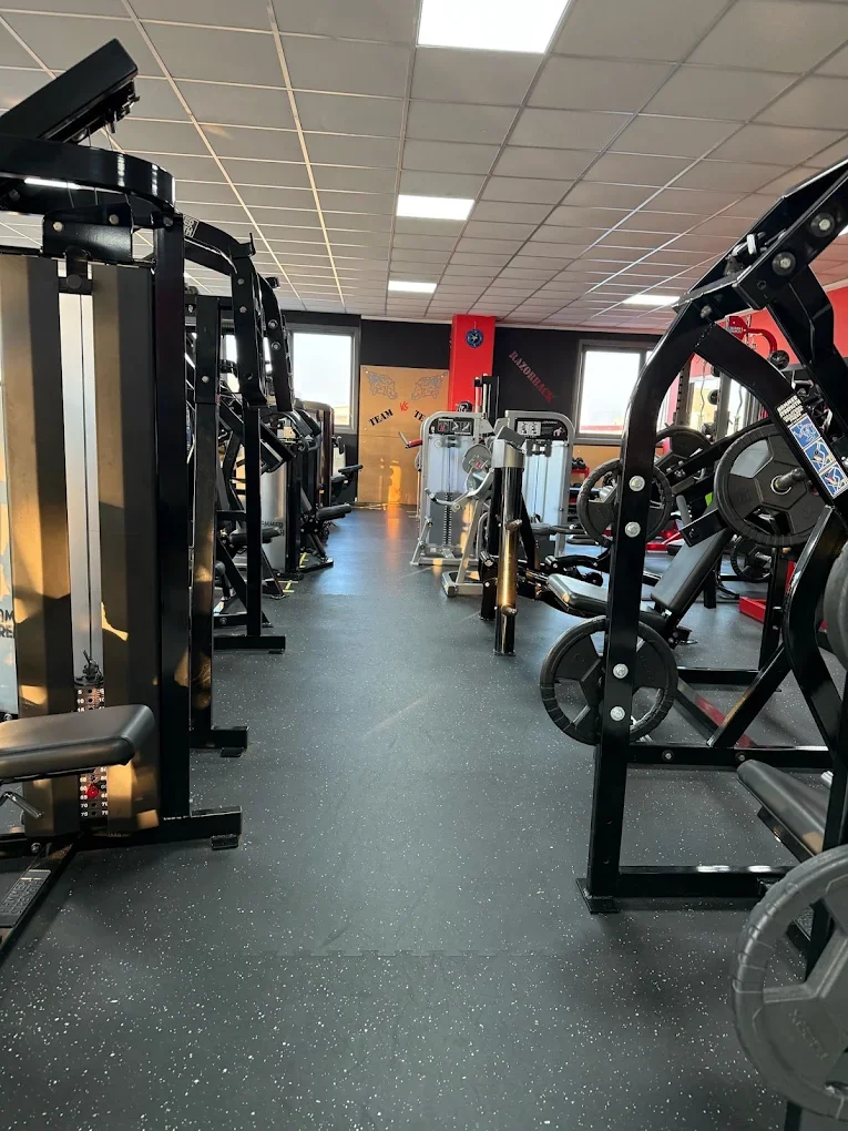 Sala pesi con attrezzi da palestra, come cyclette e macchinari per sollevamento pesi, in un centro fitness.