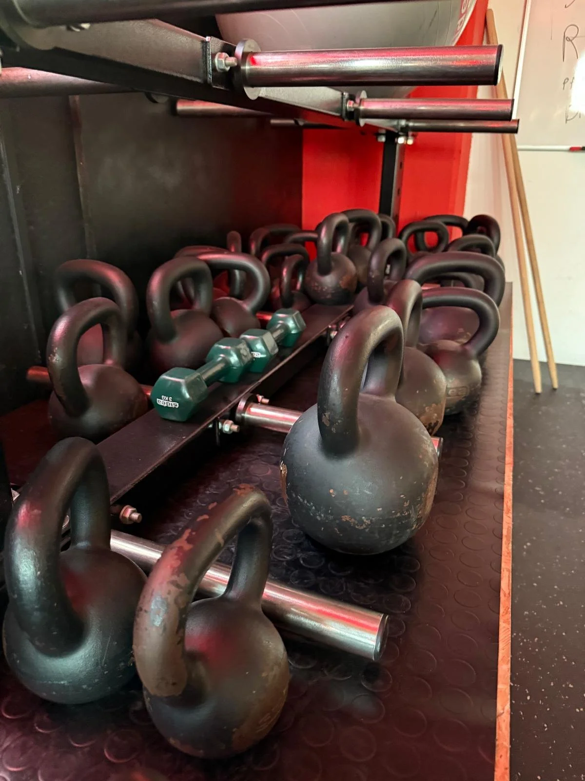 Set di kettlebell, manubri e barre in palestra.