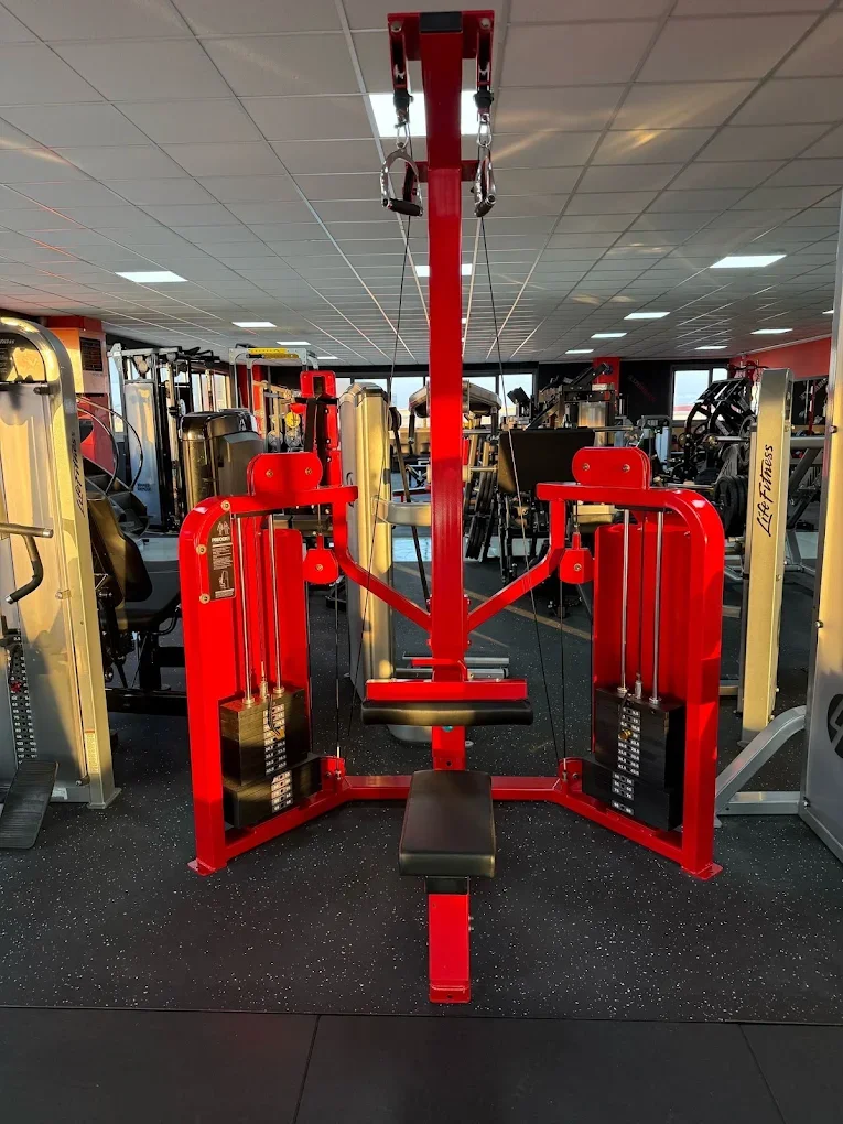 Attrezzo da palestra per trazioni in piedi con barra e cavi in un gym.