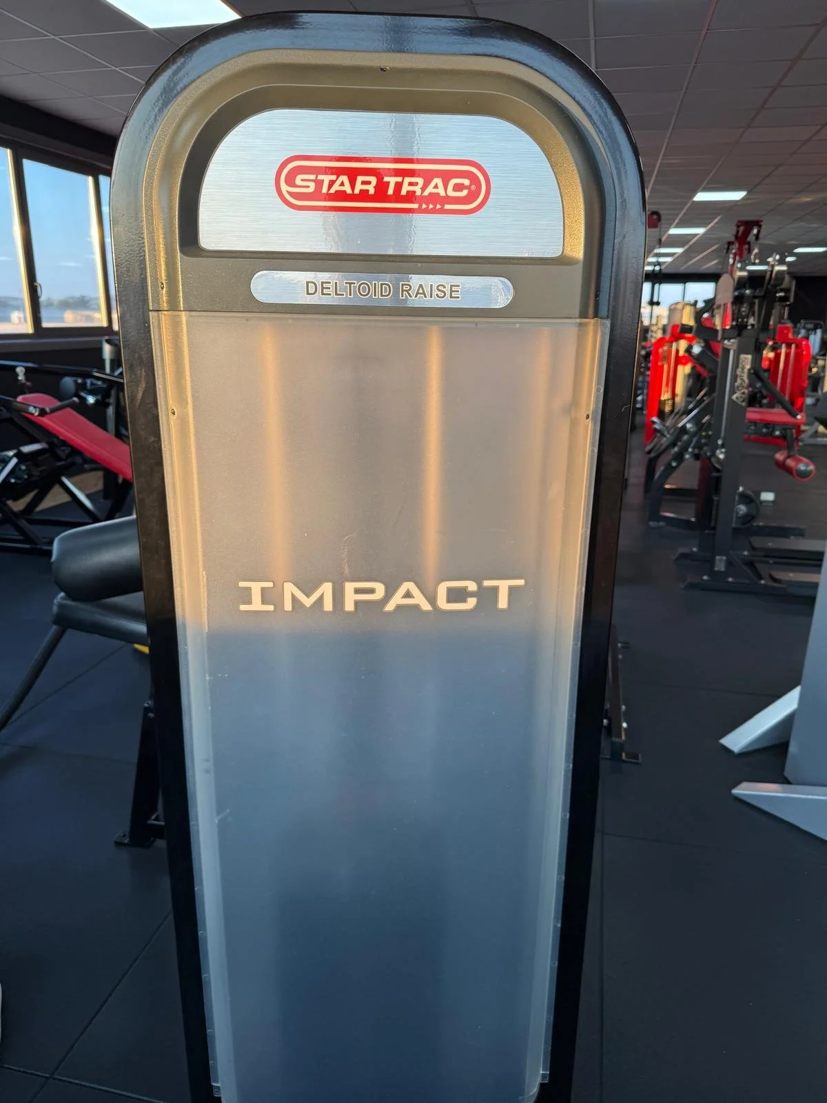 Attrezzo di palestra di marca Star Trac per sollevamento pesi, modello Impact, con funzione di sollevamento del deltoide.