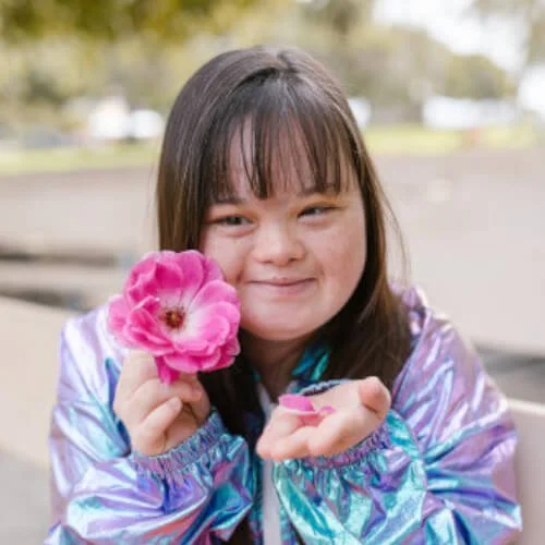 Girl with Down syndrome holding a flower