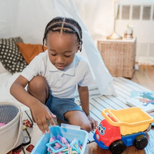 A boy with autism picks up his toys