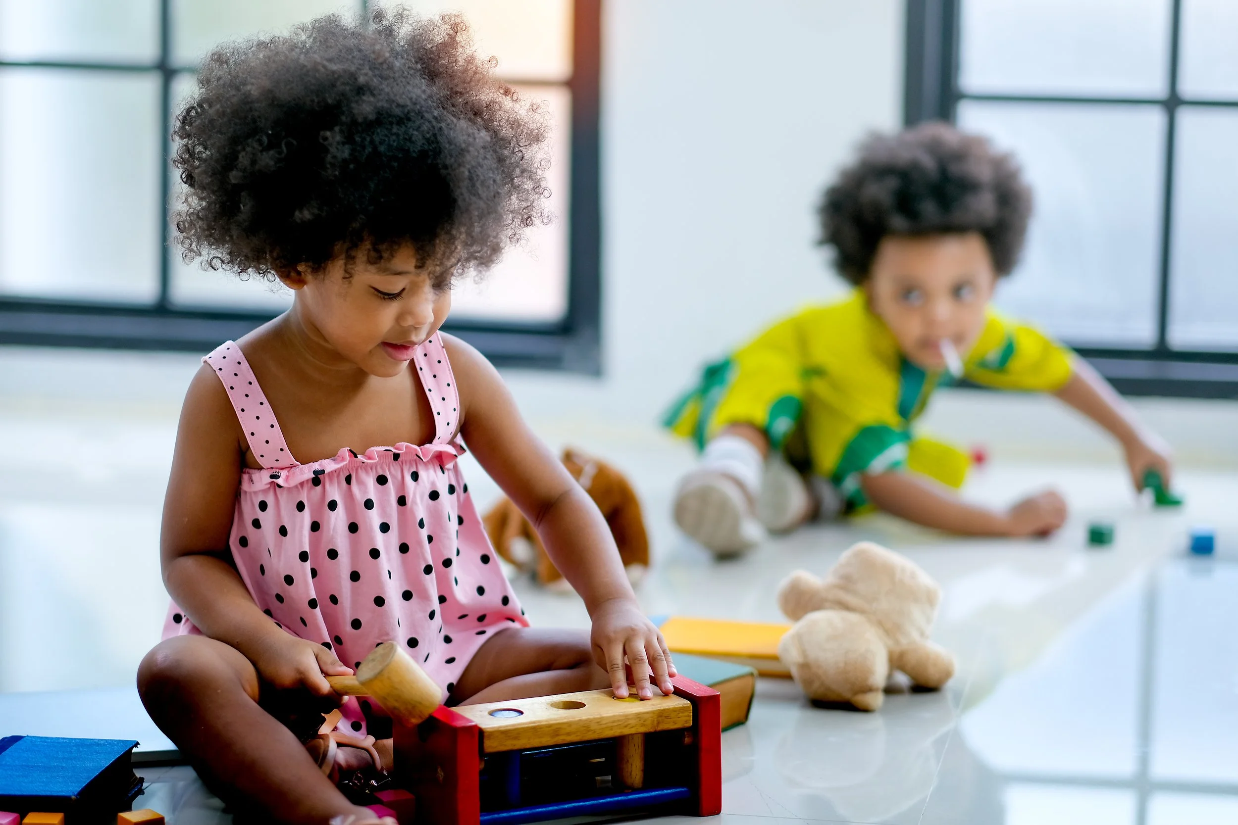 Two young toddlers playing with Montessori toys together.