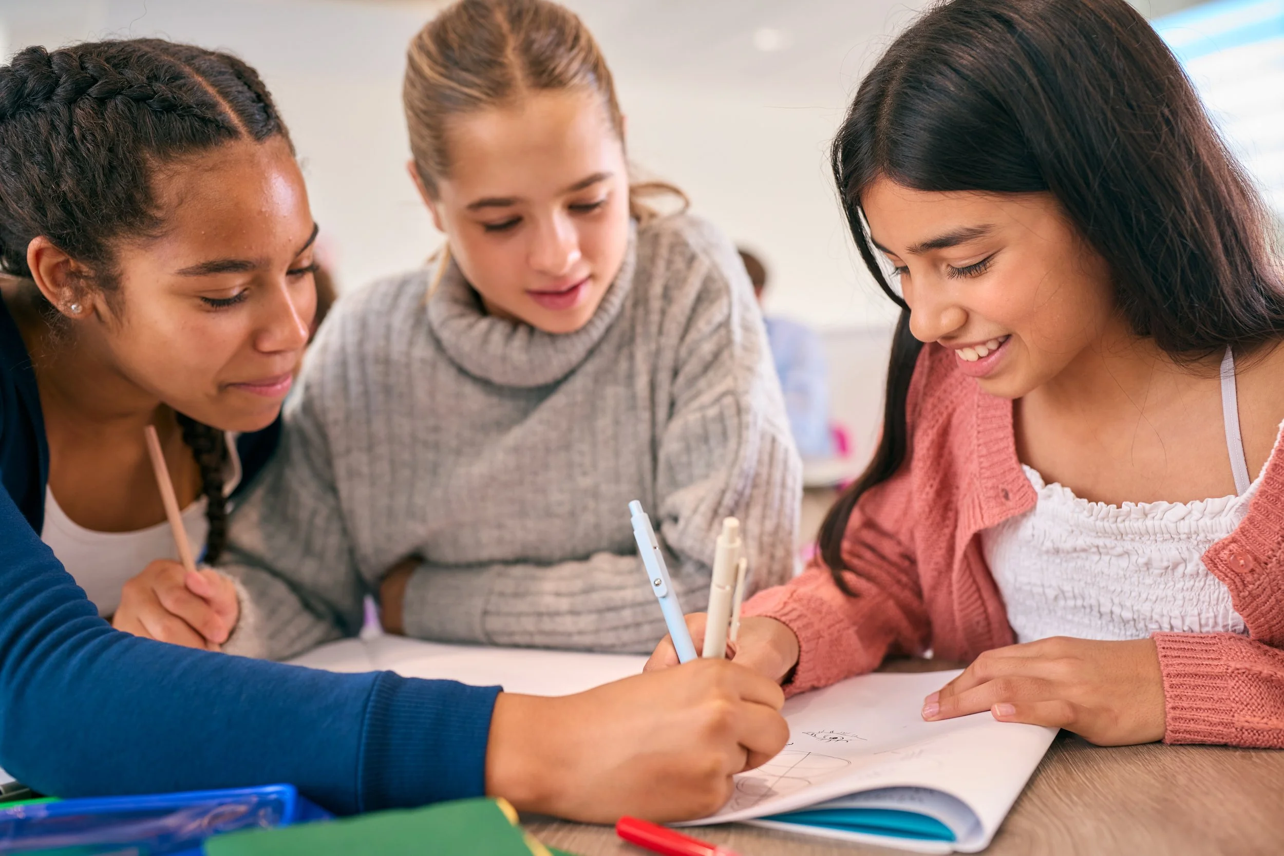 3 tween girls working together on a project.