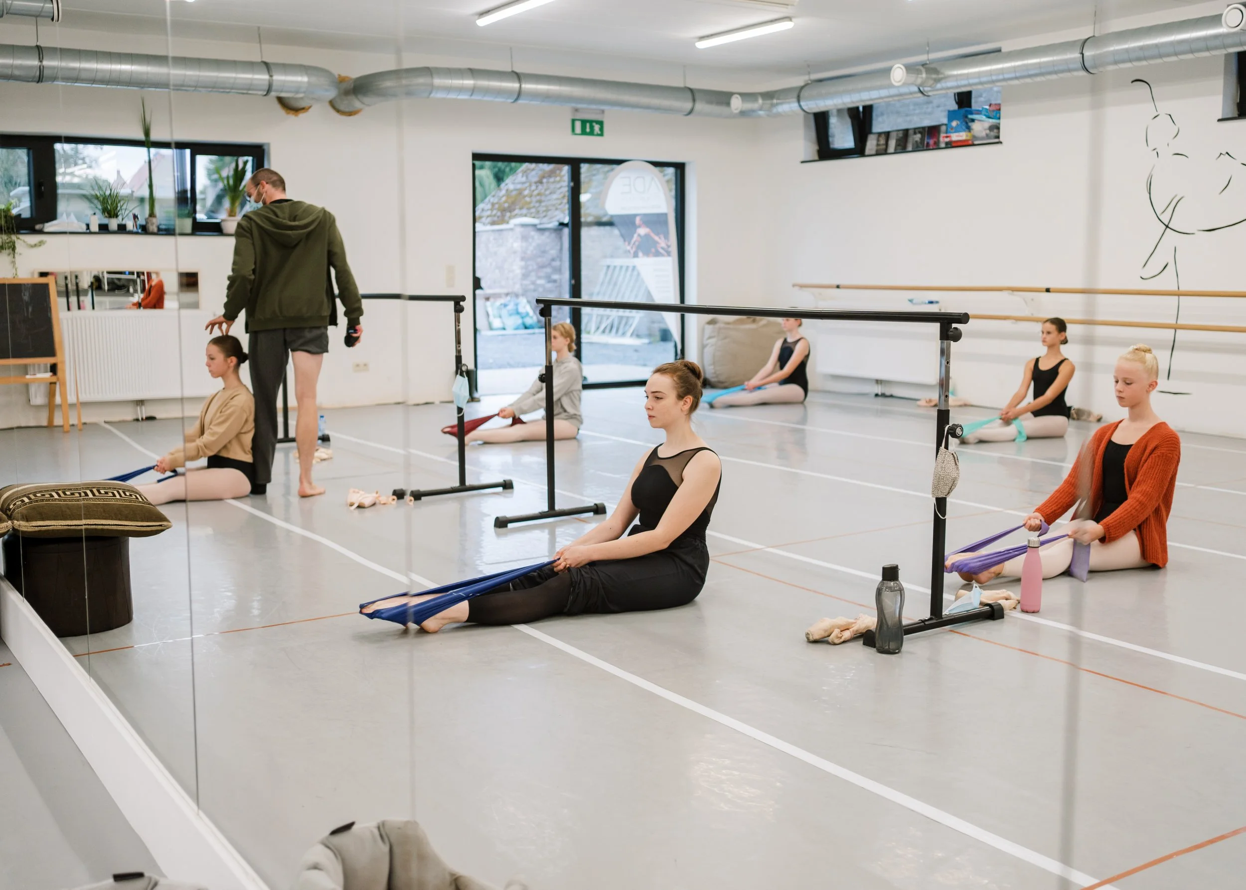 Balletdansers die in een dansstudio aan het stretchen zijn