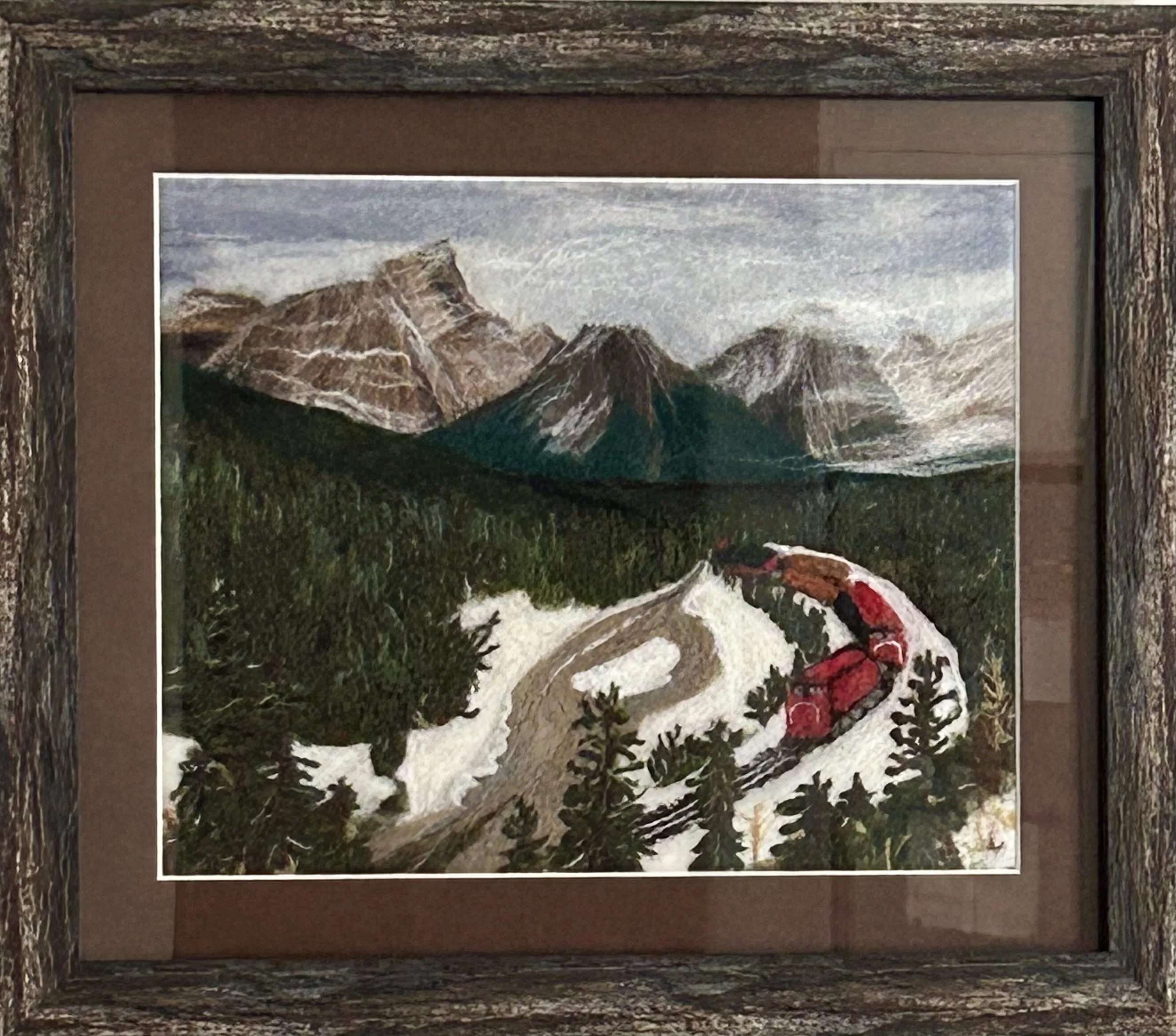 Needle felted landscape depicting Morant's Curve in winter, with mountains, a train and large pine tree in the foreground