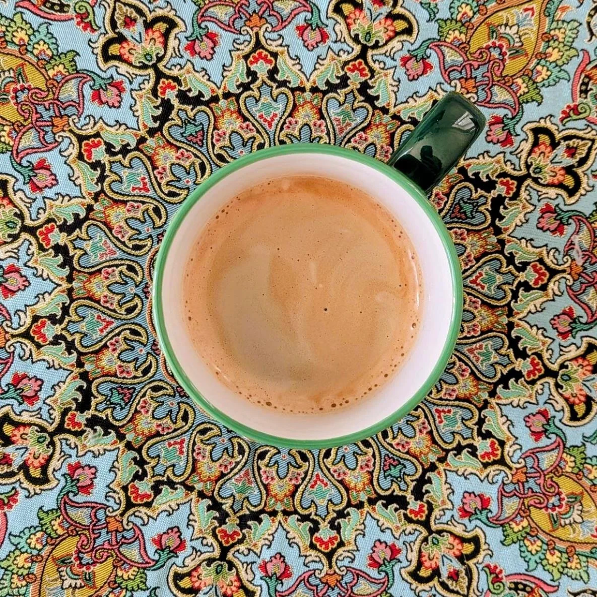 A cup of coffee on a beautiful Persian Termeh cloth.