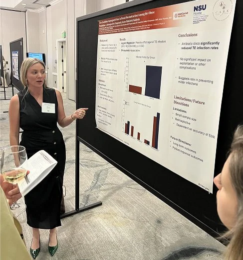 Medical student presenting poster at resident symposium at CSPS