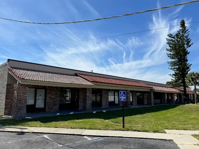 Single-story commercial building home to Ocean Park Wellness with brick exterior, large front windows, and a handicap parking sign outside.