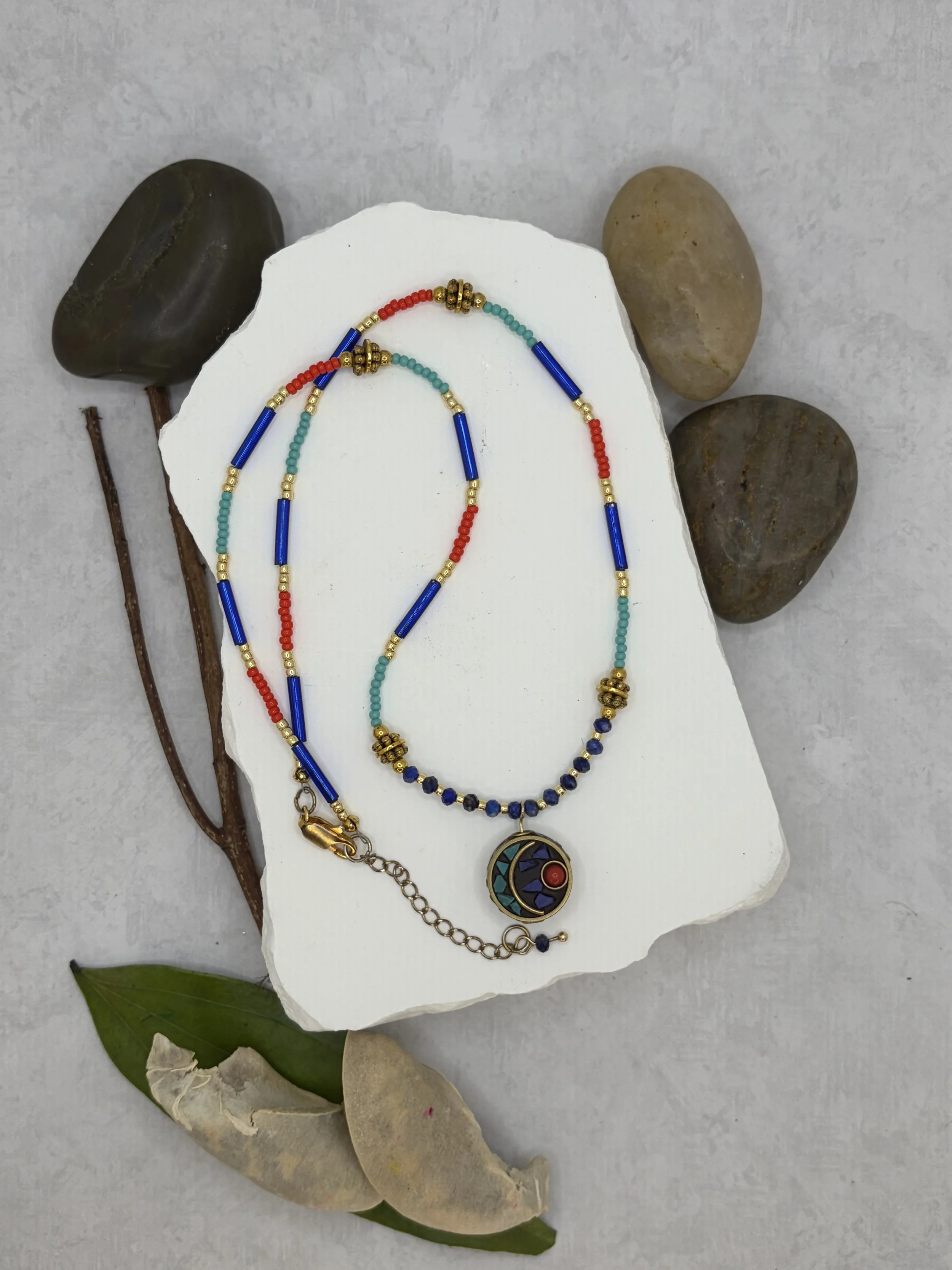 handmade beaded necklace with round Tibetan brass turquoise coral inlay charm and faceted lapis lazuli beads
