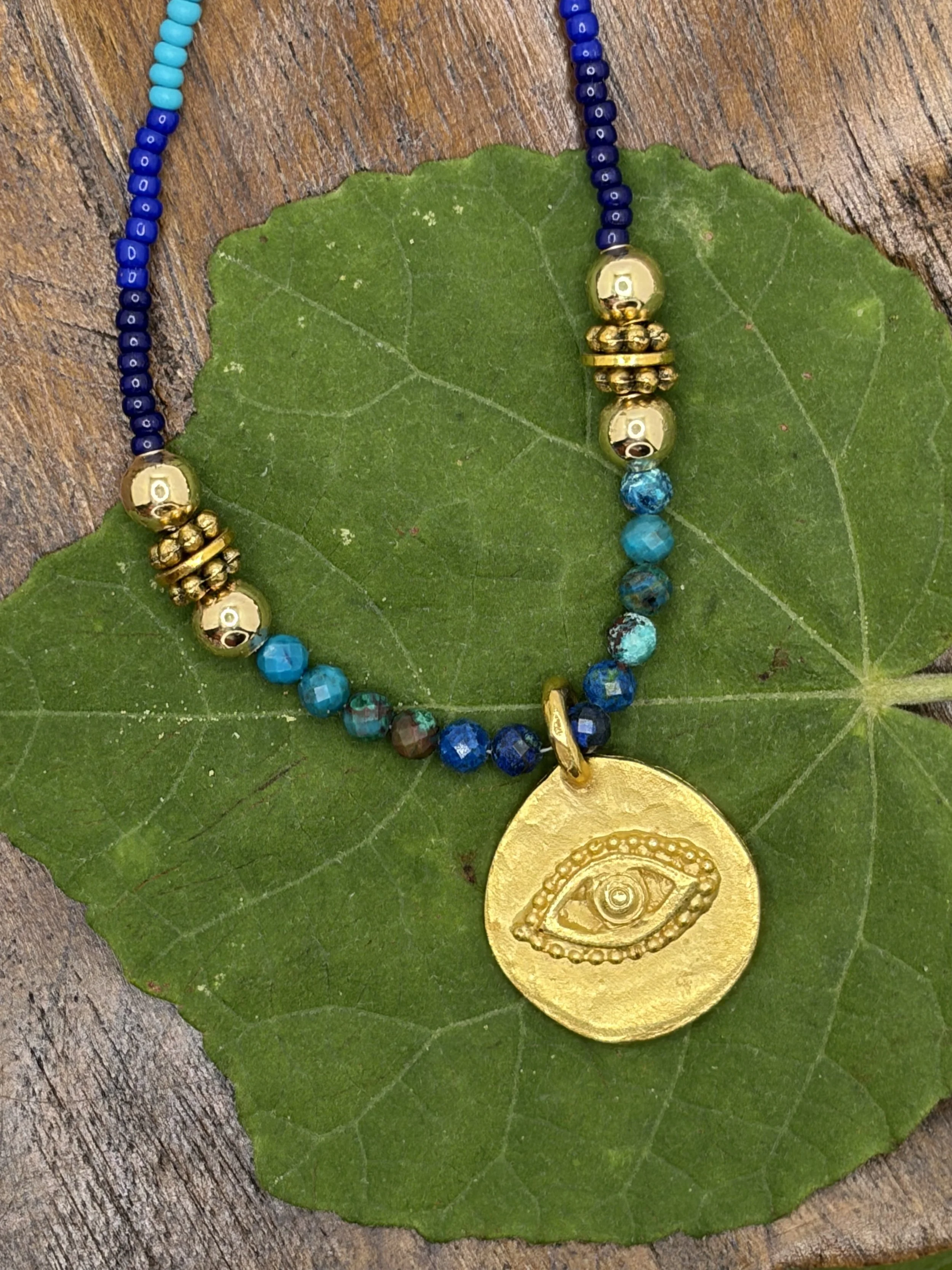 Handmade ombré seed bead necklace with faceted chrysocolla beads and a gold-tone evil eye charm pendant