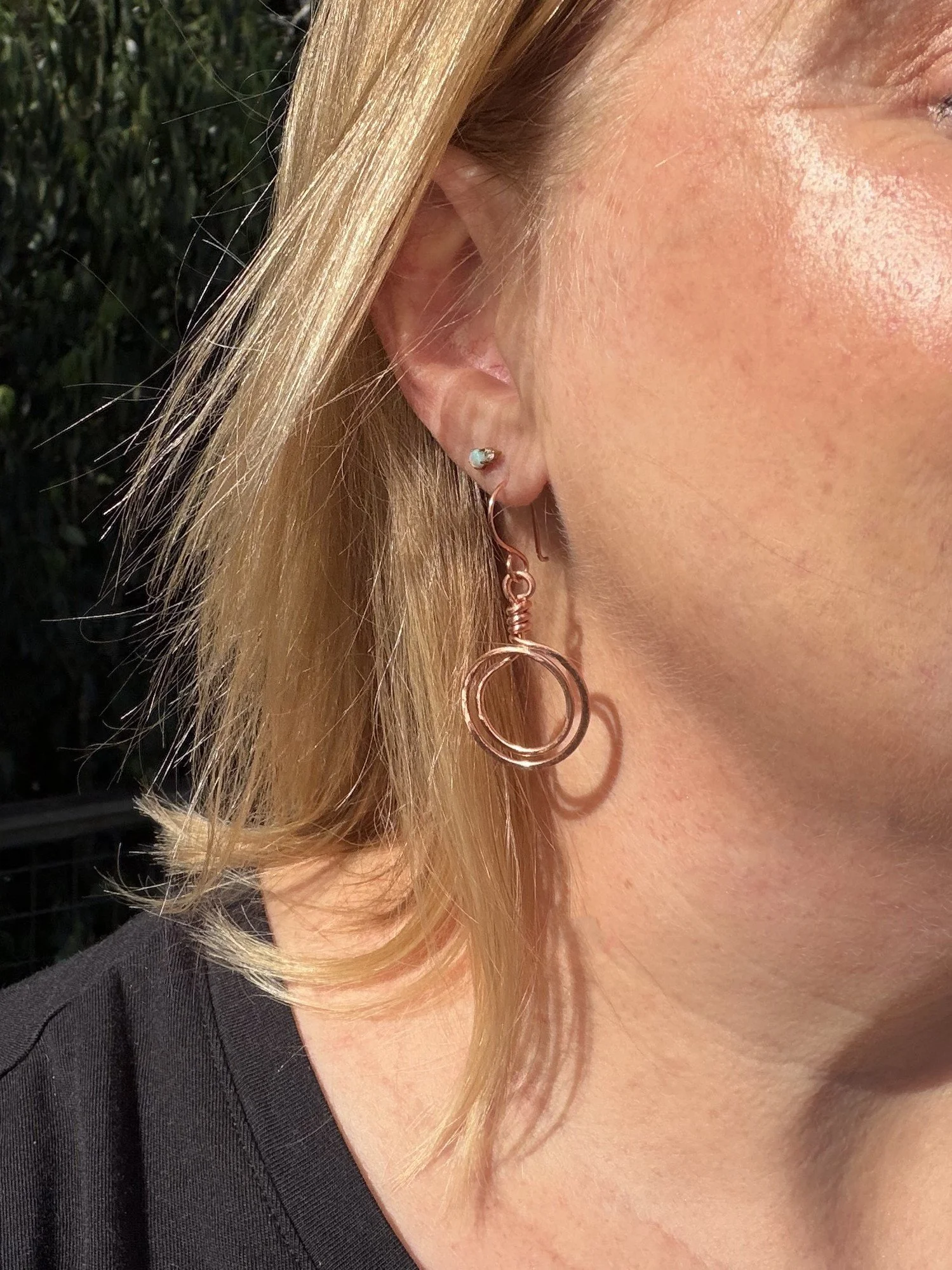 woman wearing handmade hammered copper double loop dangle earrings