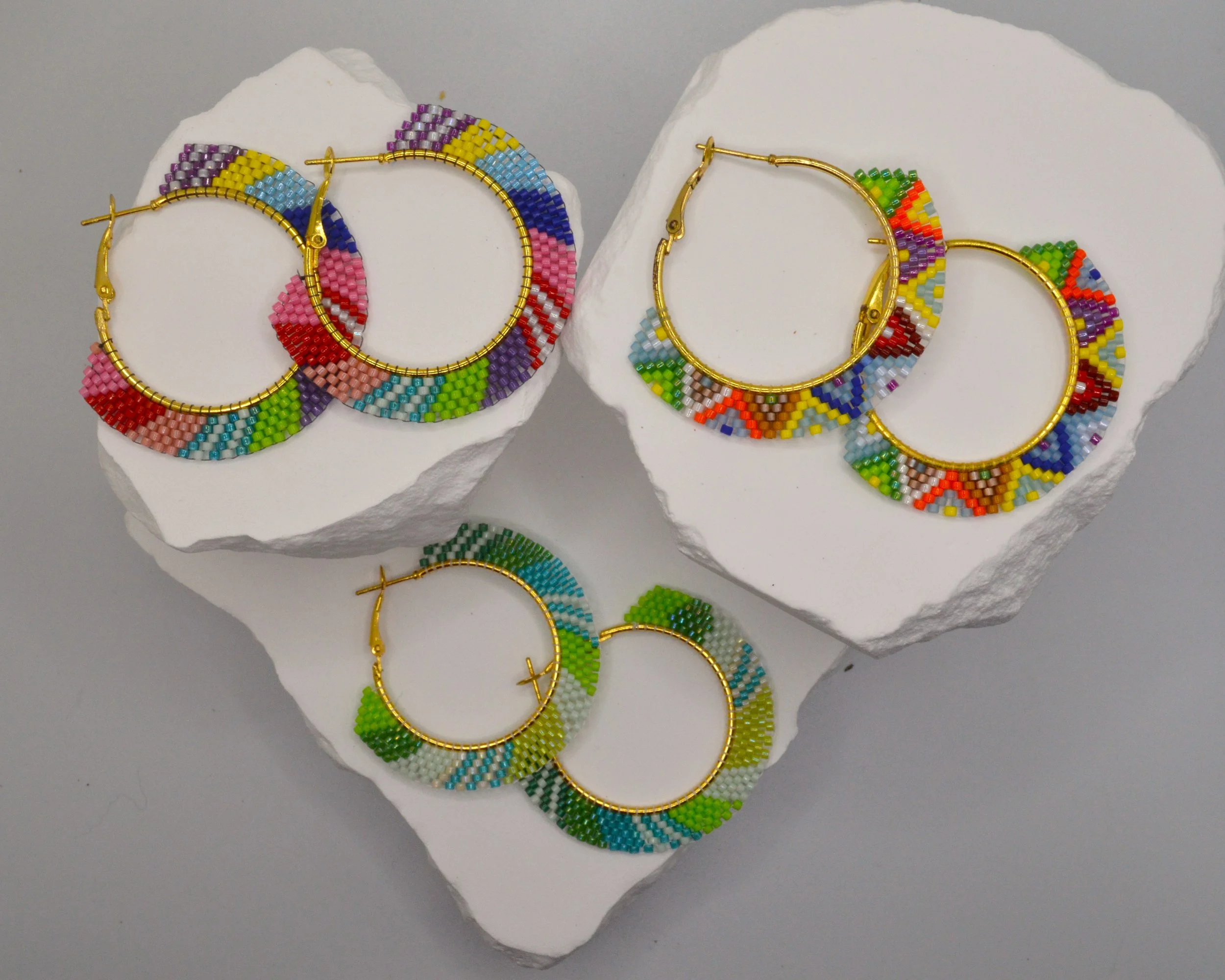 Green, teal, white and lime seed bead woven hoop earrings in gold-tone metal.