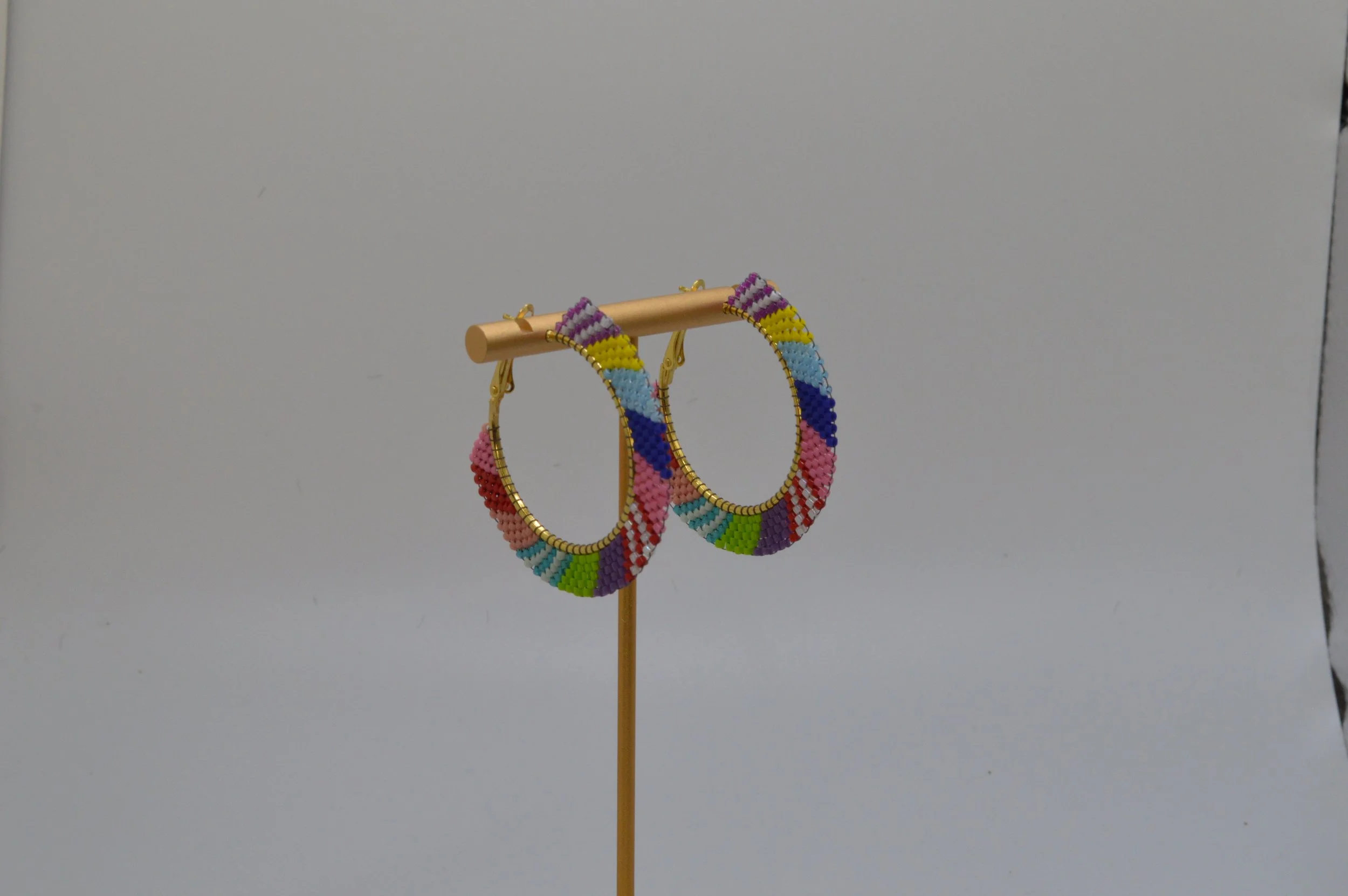 Multicolor colorblock seed bead woven hoop earrings in gold-tone metal.